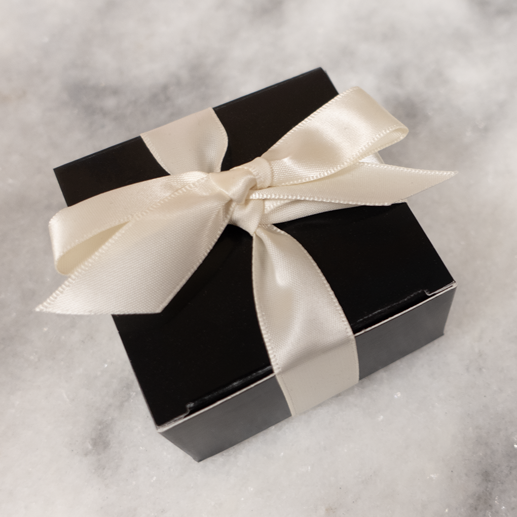 little black 4 piece box closed with a off-white cream ribbon bow