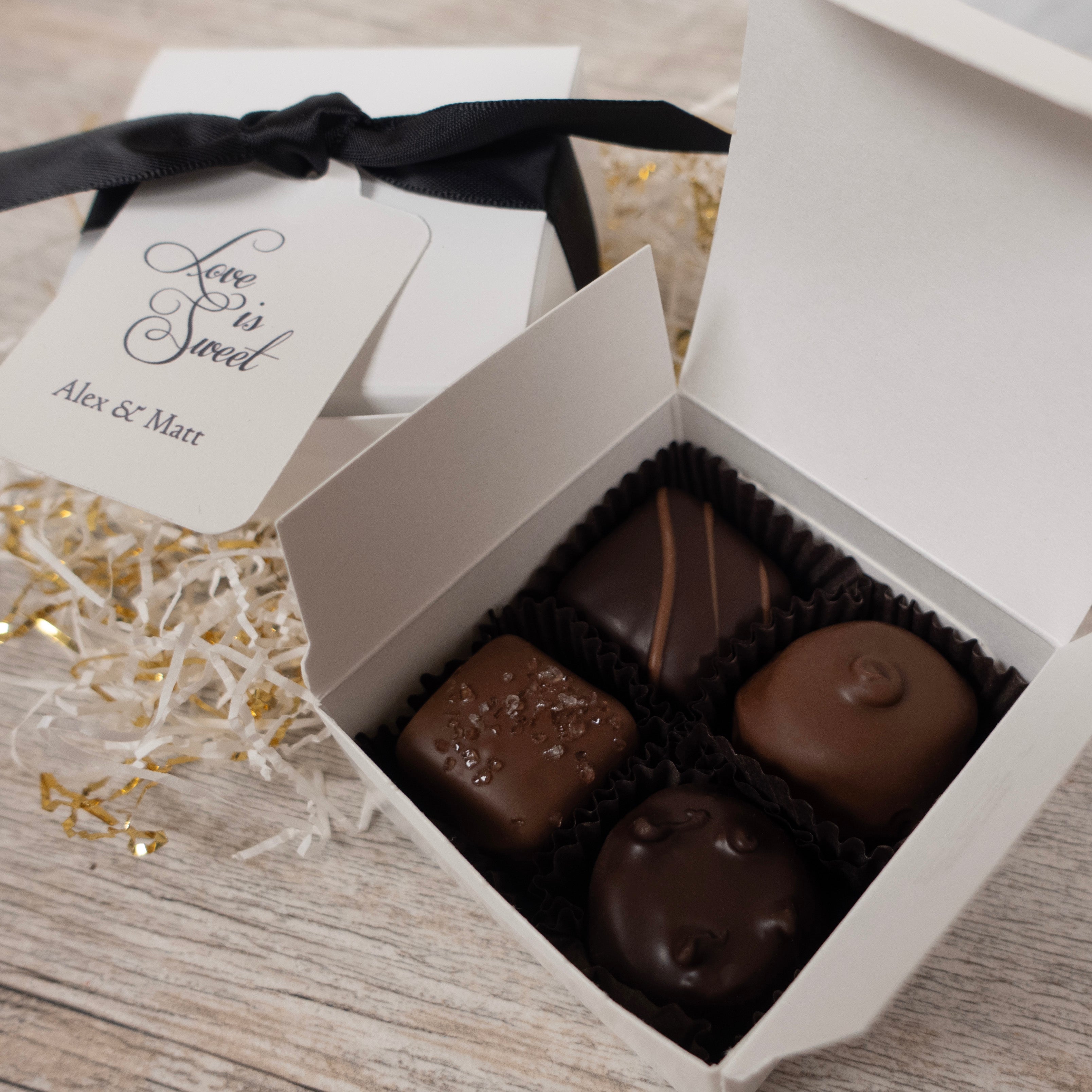 Box of 4 chocolates with a 'Love is Sweet' card on a wooden surface