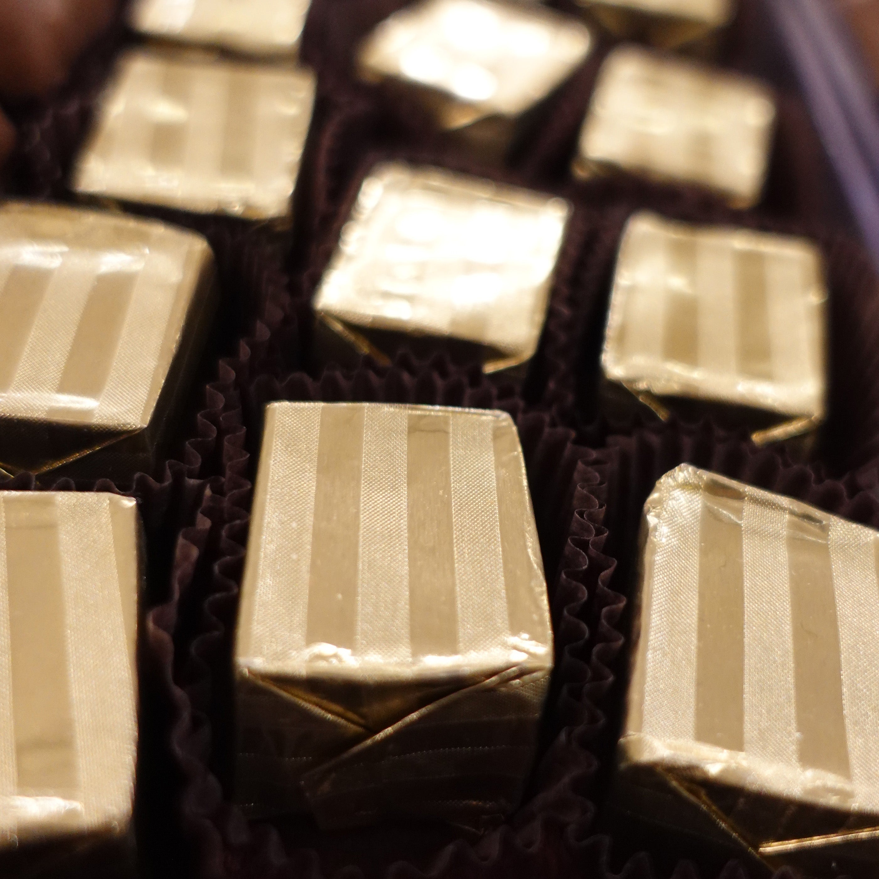 Hazelnut Truffles (figaros) individually wrapped in a striped gold foil.