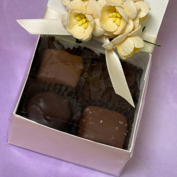 A 4 piece gift box of chocolates includes caramel, sea salt caramel, buttercream, solid chocolate LOVE