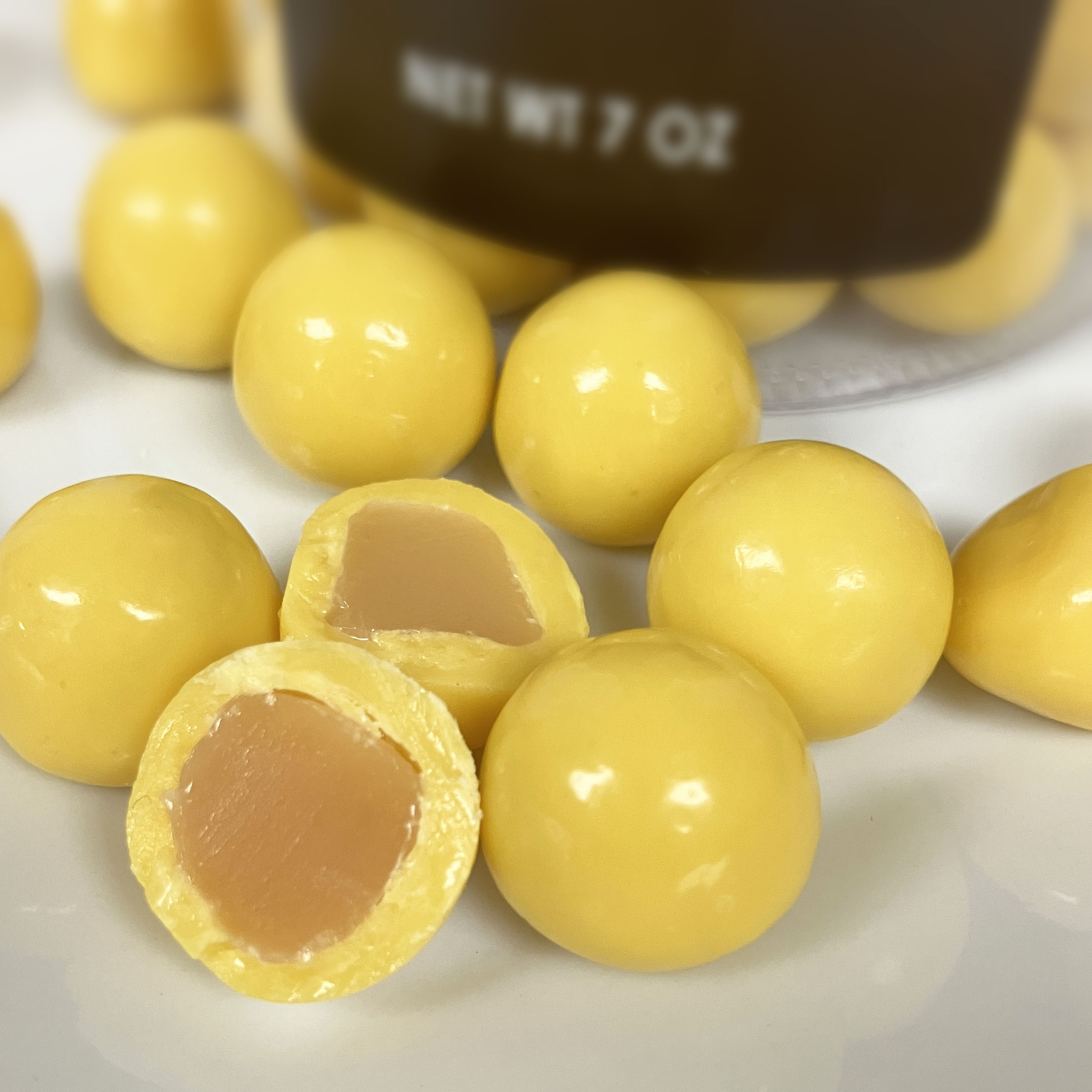 Yellow lemon flavored caramel candies up close detail shot showing the light caramel inside the candies.