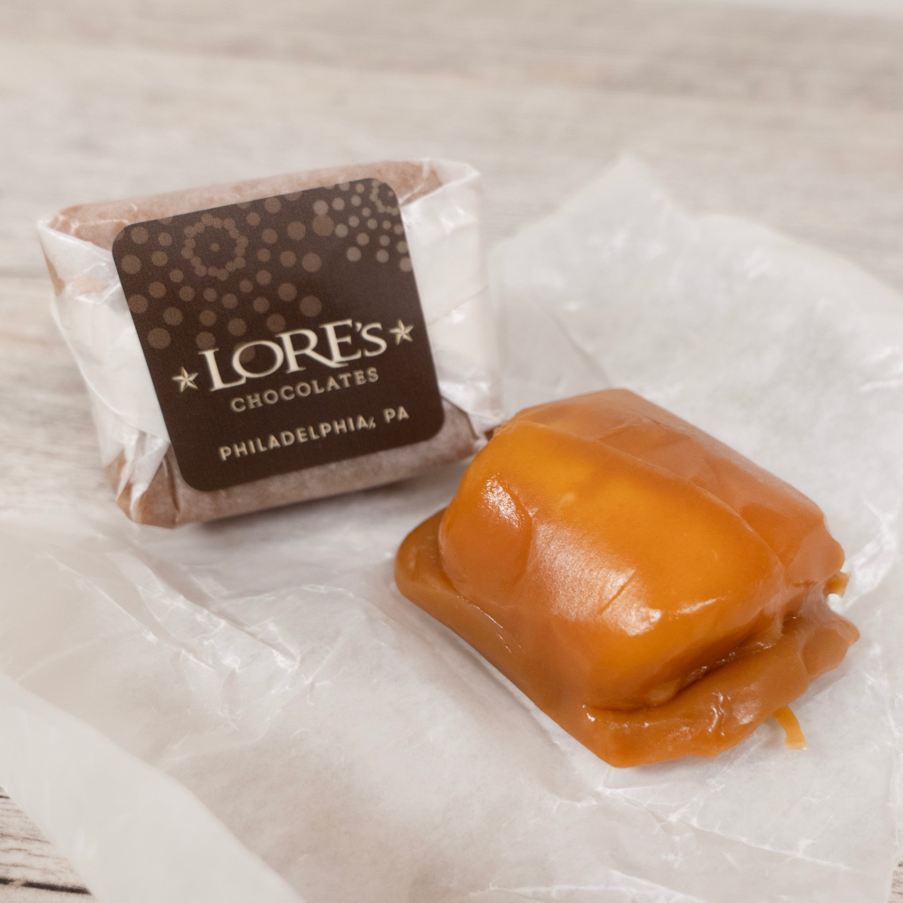 Lore's Chocolates of Philadelphia, PA on the wrapper of the handmade caramellos and an open caramello covered in chewy caramel