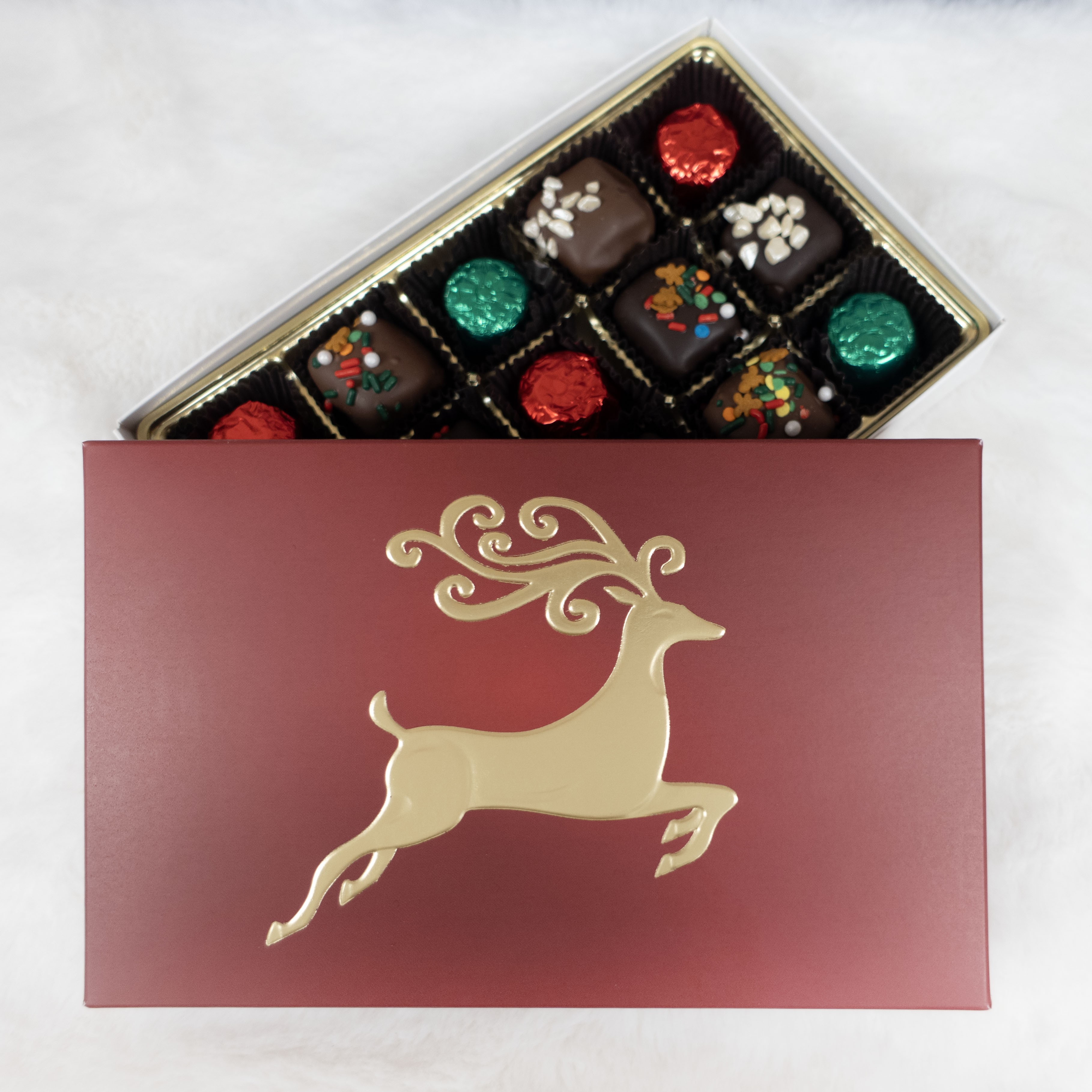 maroon/red Chocolate box with a gold reindeer design on a white background