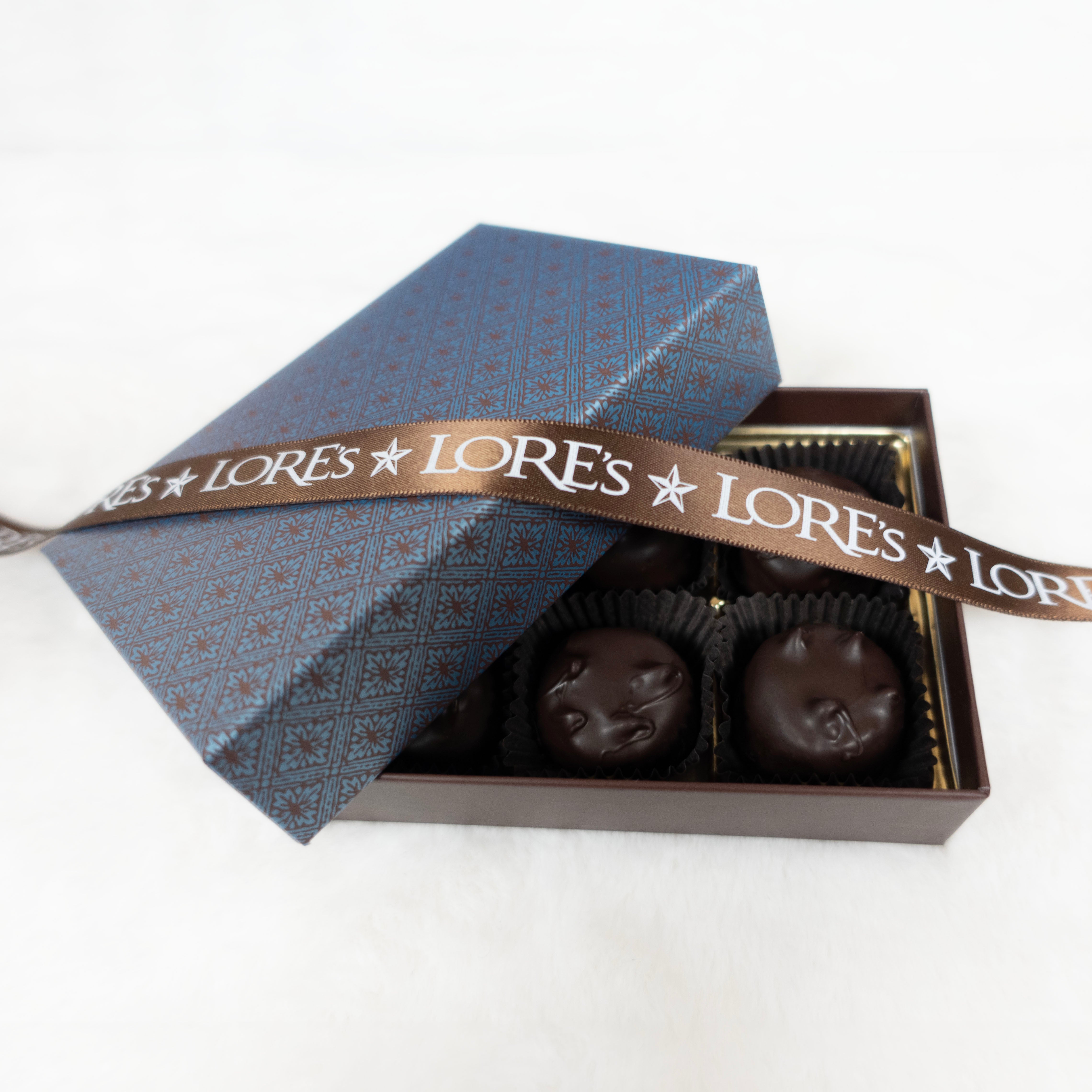 Box of chocolates with a decorative ribbon featuring 'LORE'S' branding on a white background.