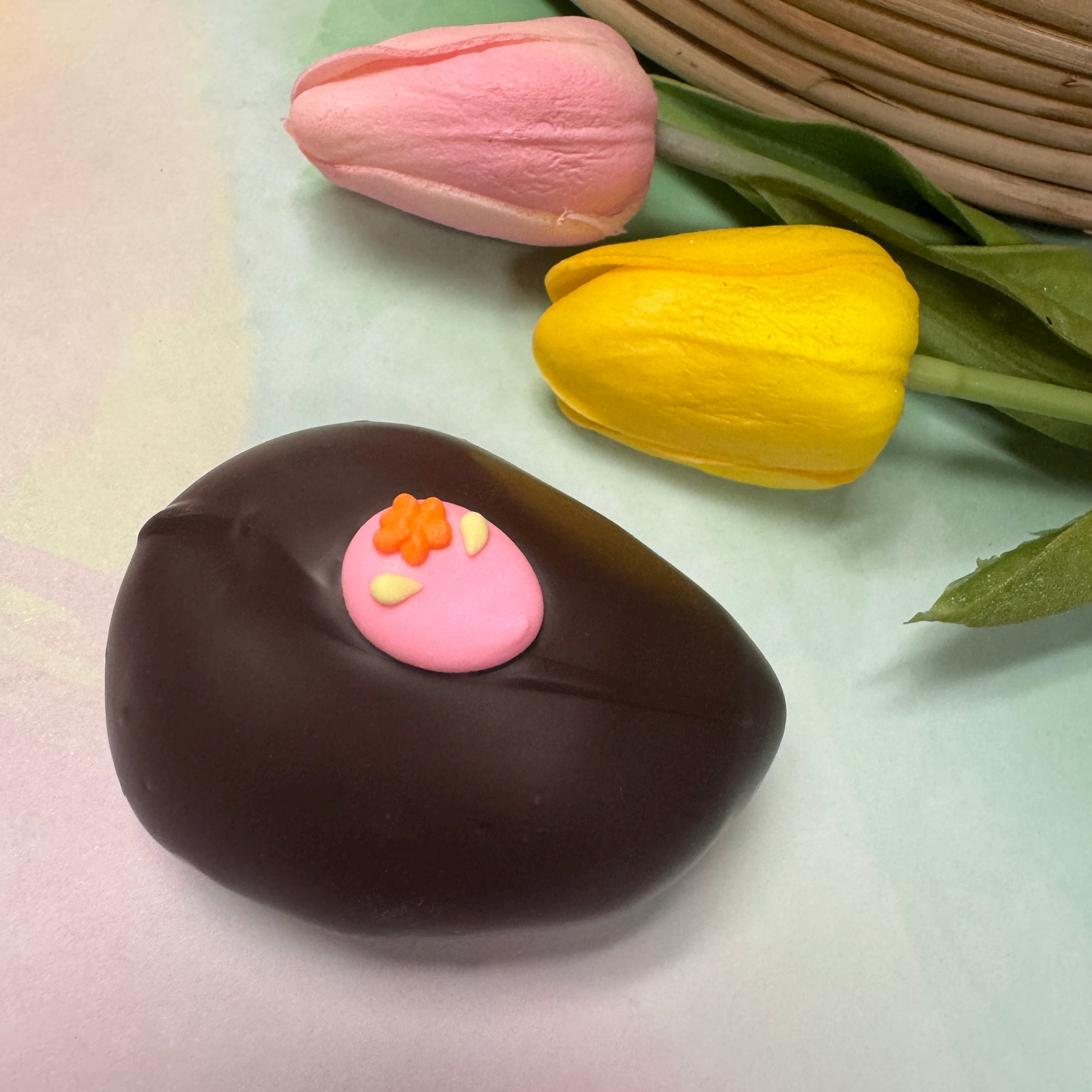 dark chocolate handmade easter egg with little pink egg sugar decoration
