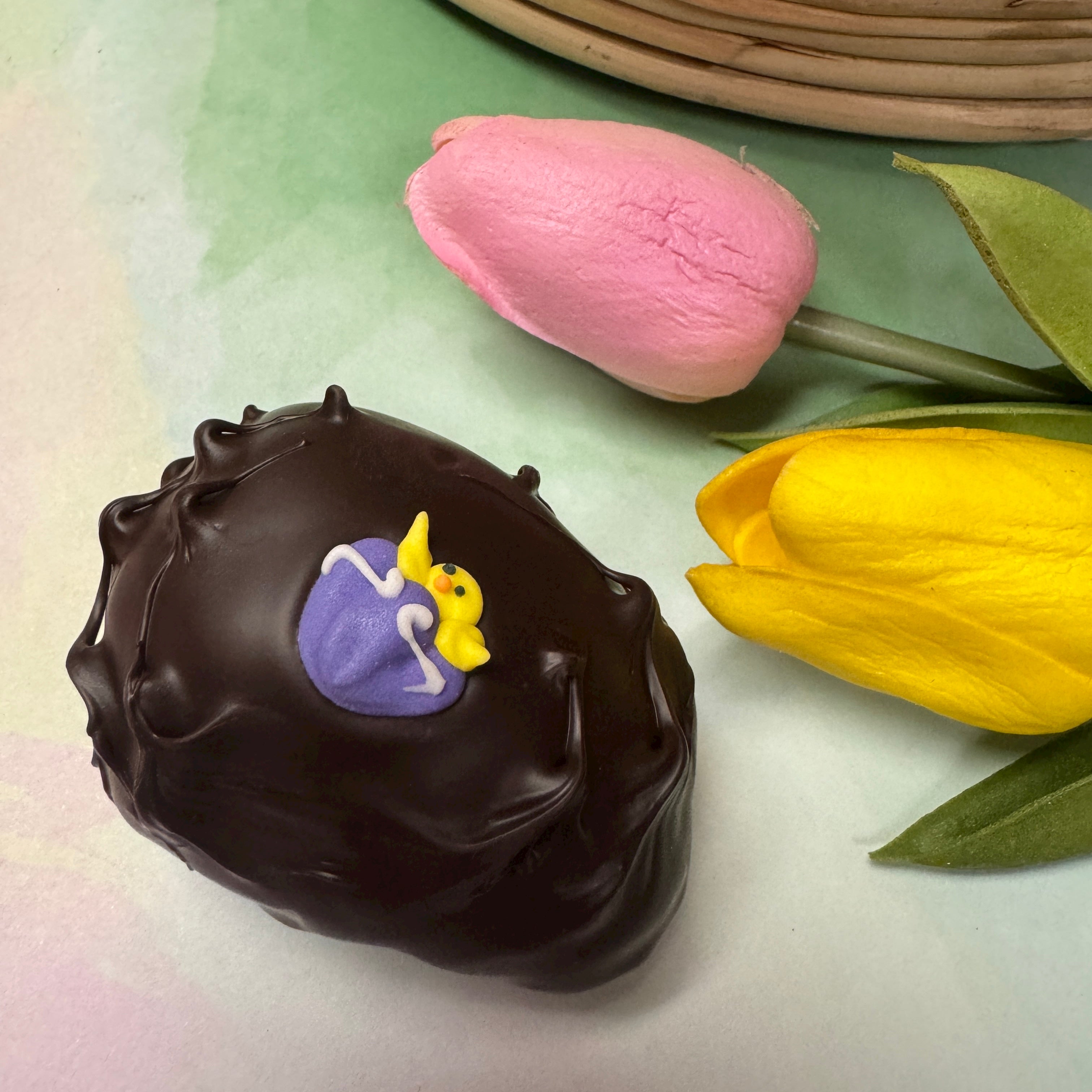 dark chocolate handmade easter egg with little purple chick sugar decoration
