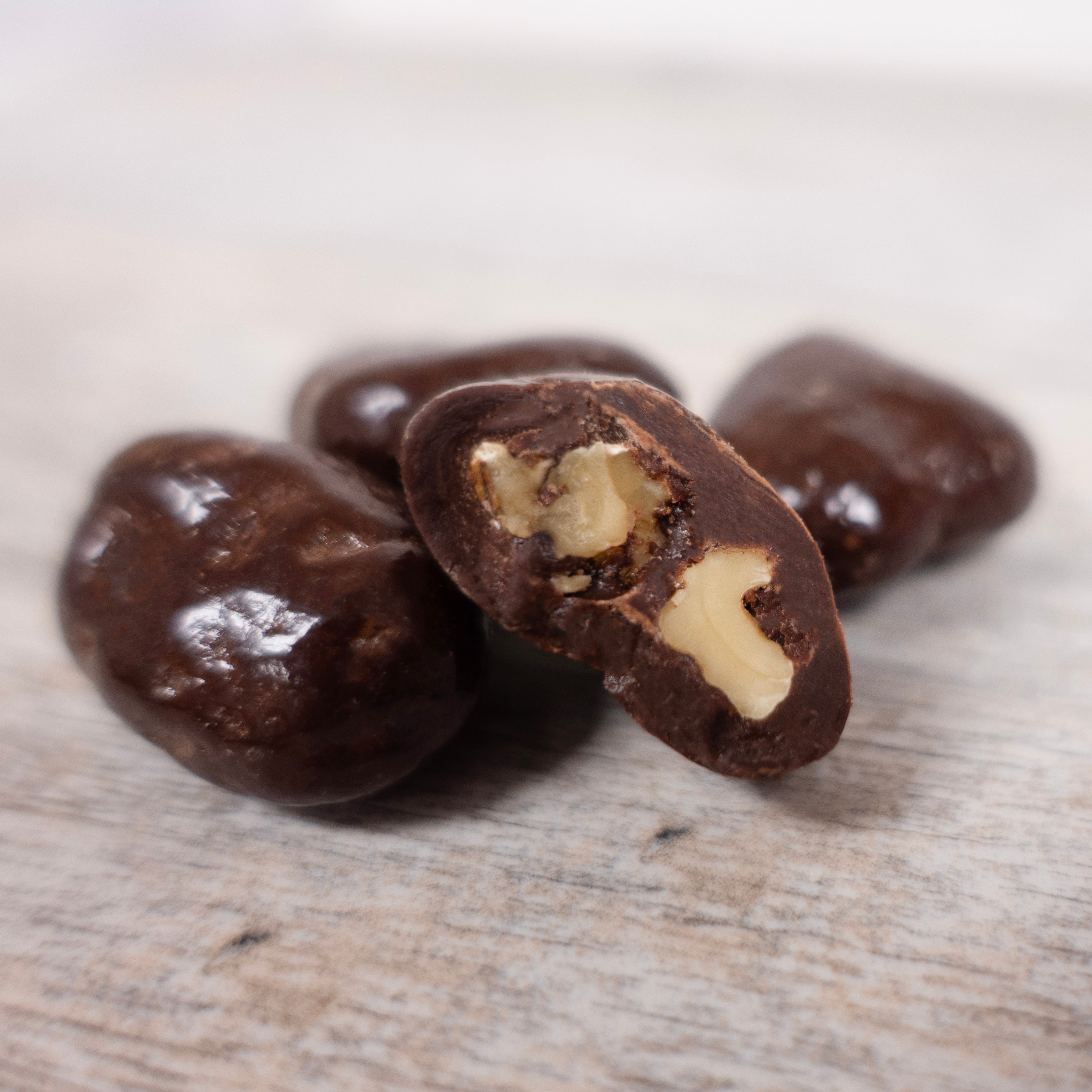 Close up detail of Dark Chocolate Walnut include a cut open piece to show inside walnut.