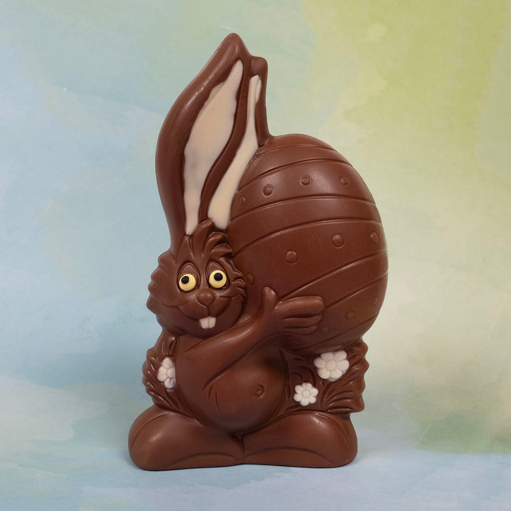 Milk Chocolate bunny holding an Easter egg against a gradient background
