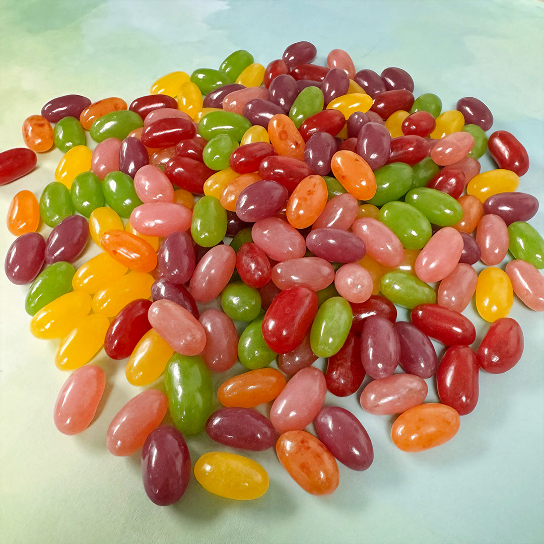Assorted colorful jelly beans on light green background