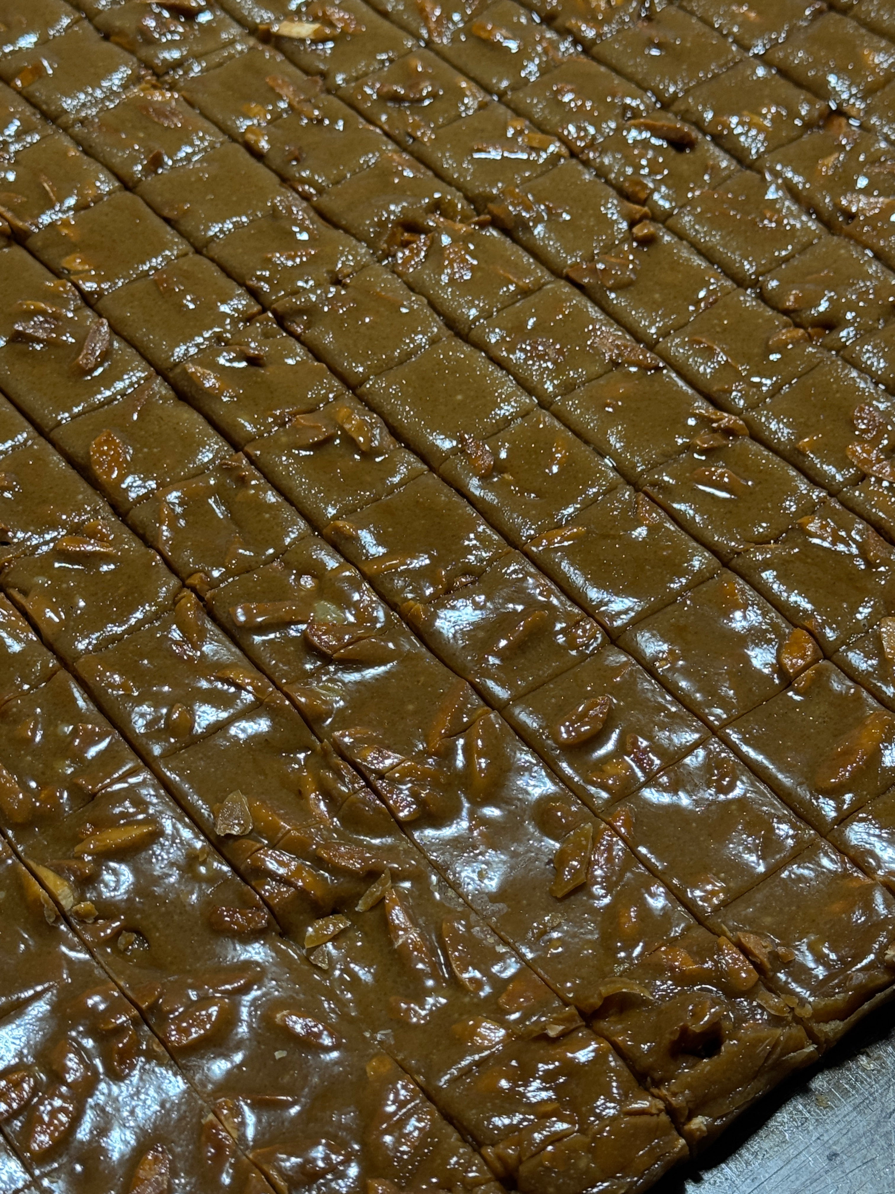 Close-up of a slab of freshly made almond toffee candy with a grid pattern cut into it