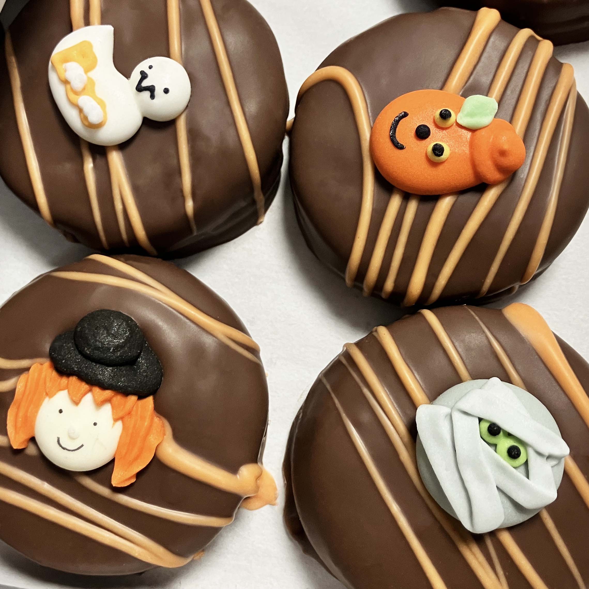 Milk Chocolate-dipped oreo cookies with Halloween-themed decorations on a white background