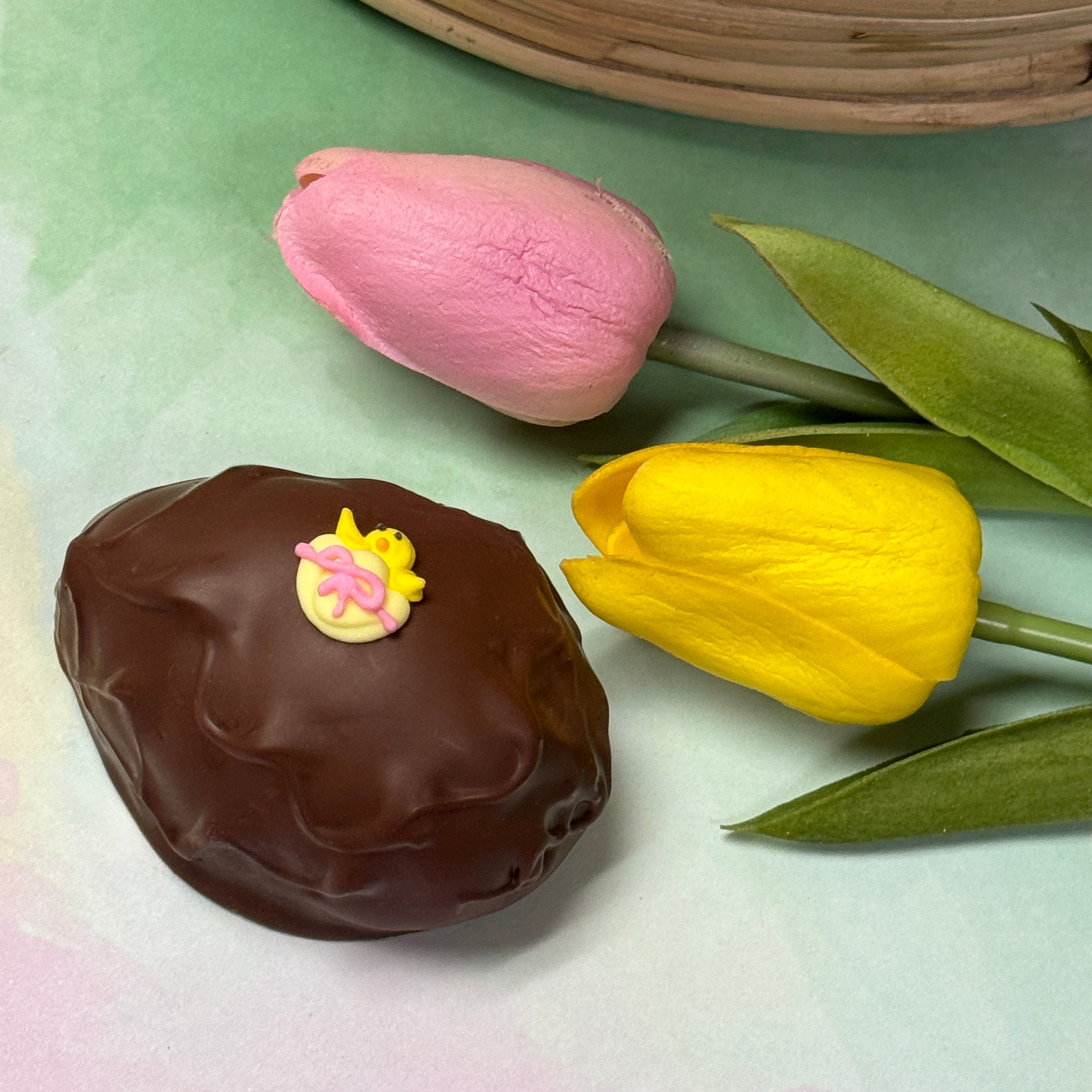 milk chocolate handmade easter egg with little yellow chick sugar decoration.