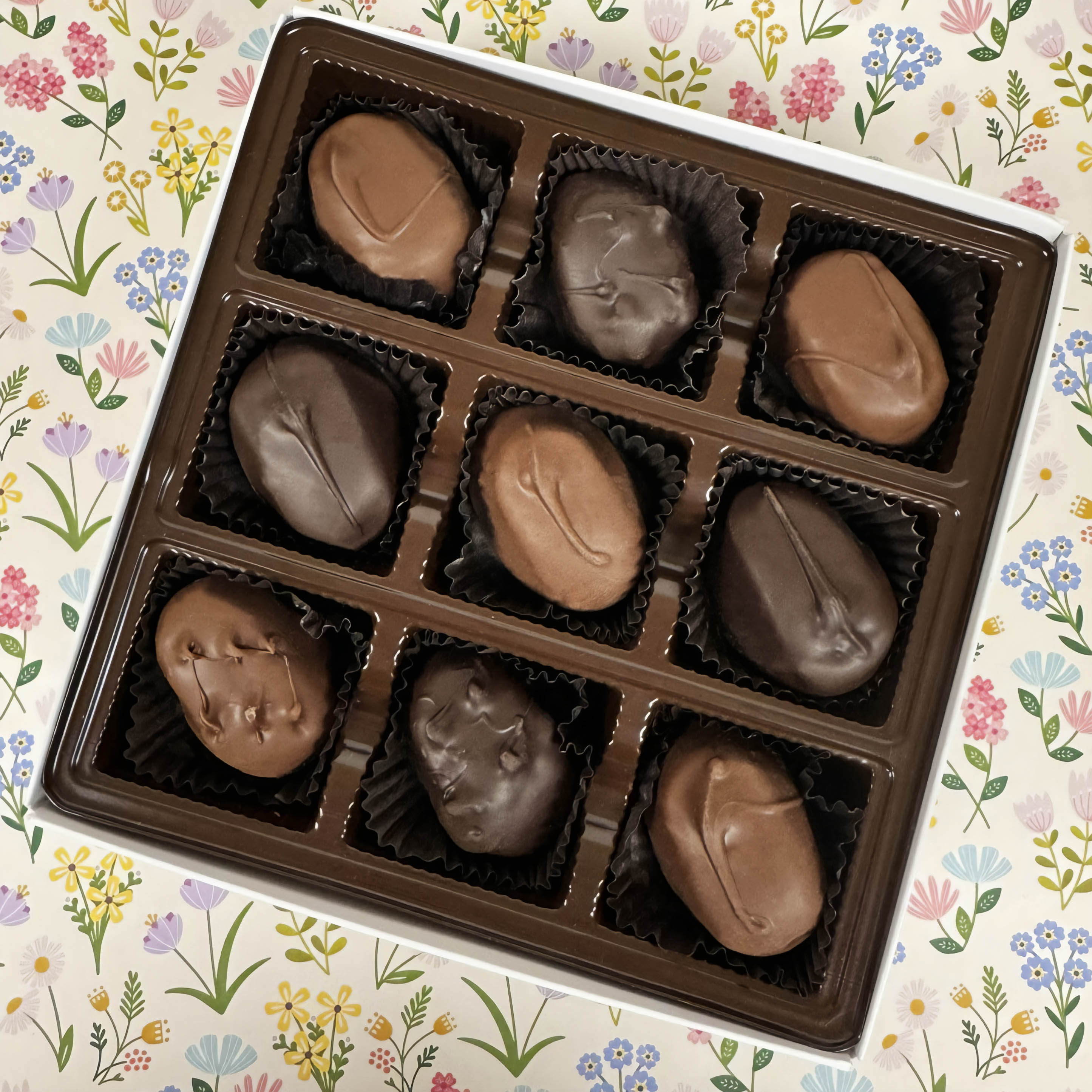 Box of chocolate candies on a floral-patterned background