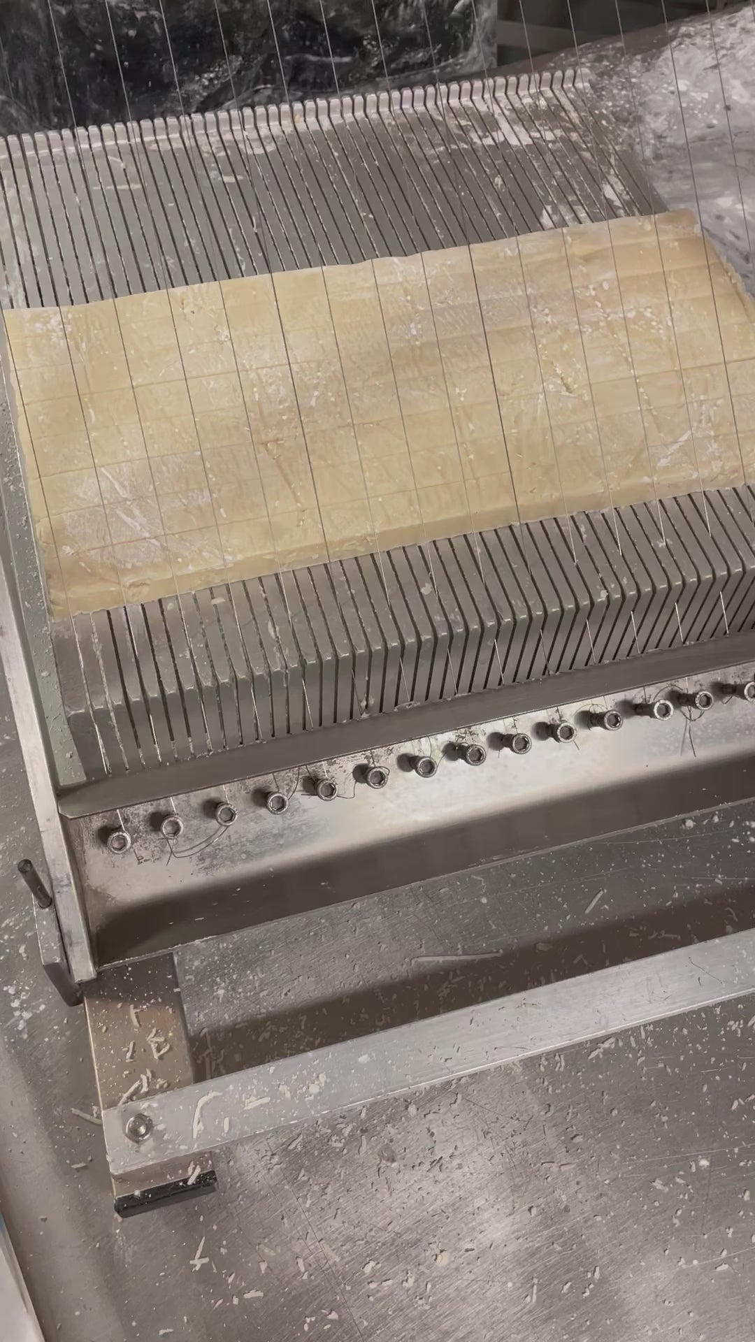 Video showing handmade marzipan almond paste being cut with guitar string cutter in Lore's Philadelphia Chocolate Factory