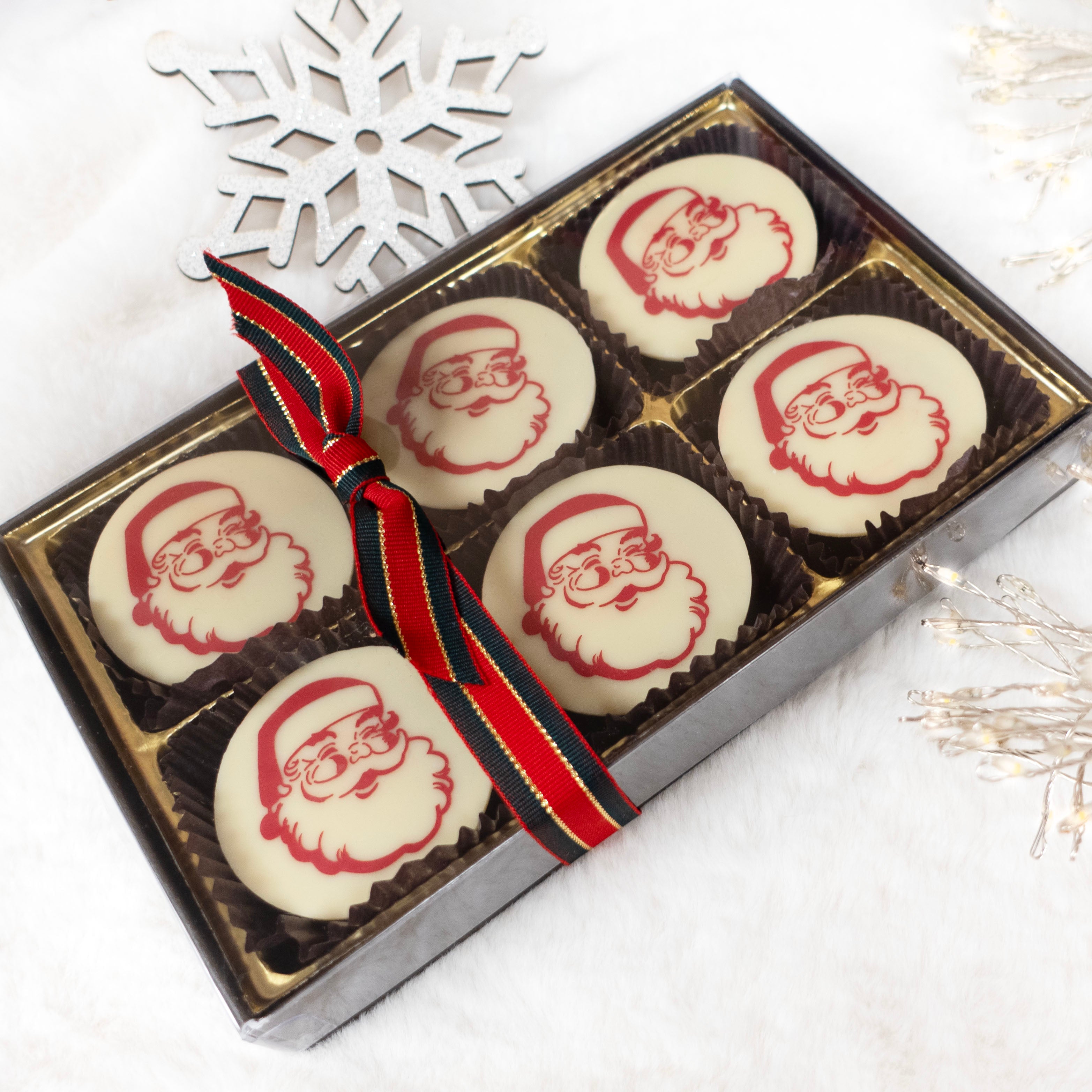 Box of chocolate oreos with Santa Claus faces on a white background