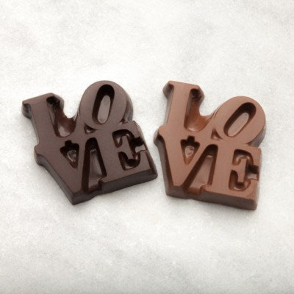 Love chocolates - one milk chocolate, one dark chocolate shaped like Philadelphia's LOVE, one white background