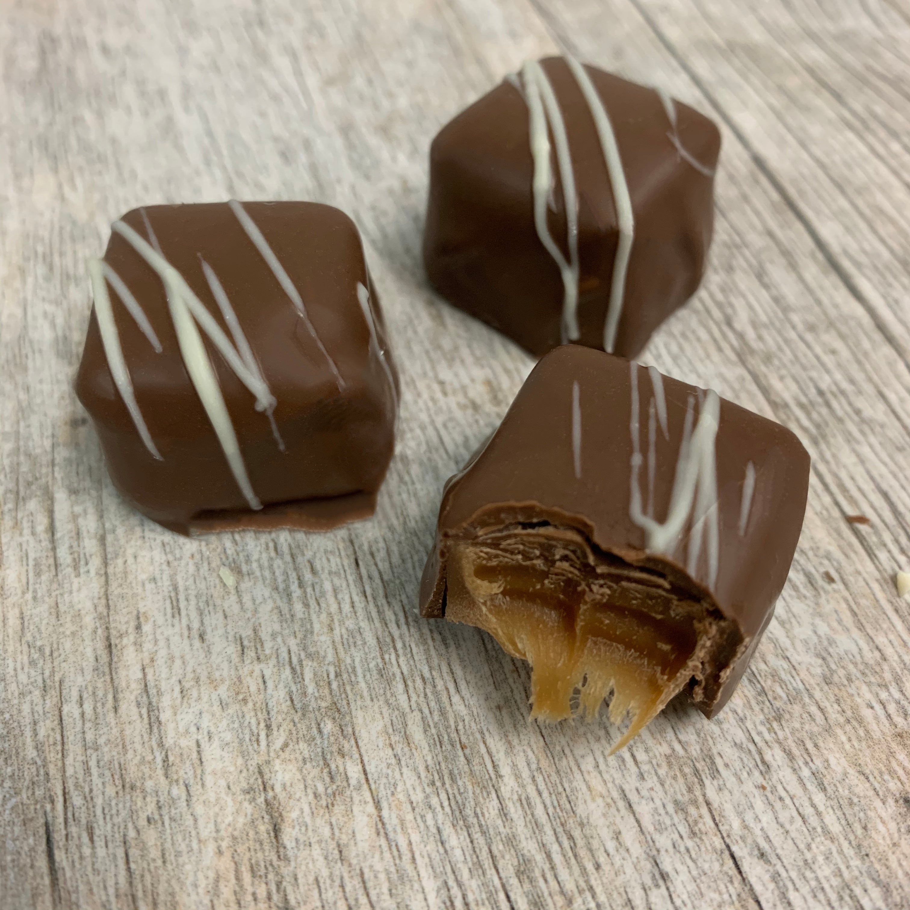Chai Caramel detail shot showing the chewy inside, decorated with stripes of white chocolate