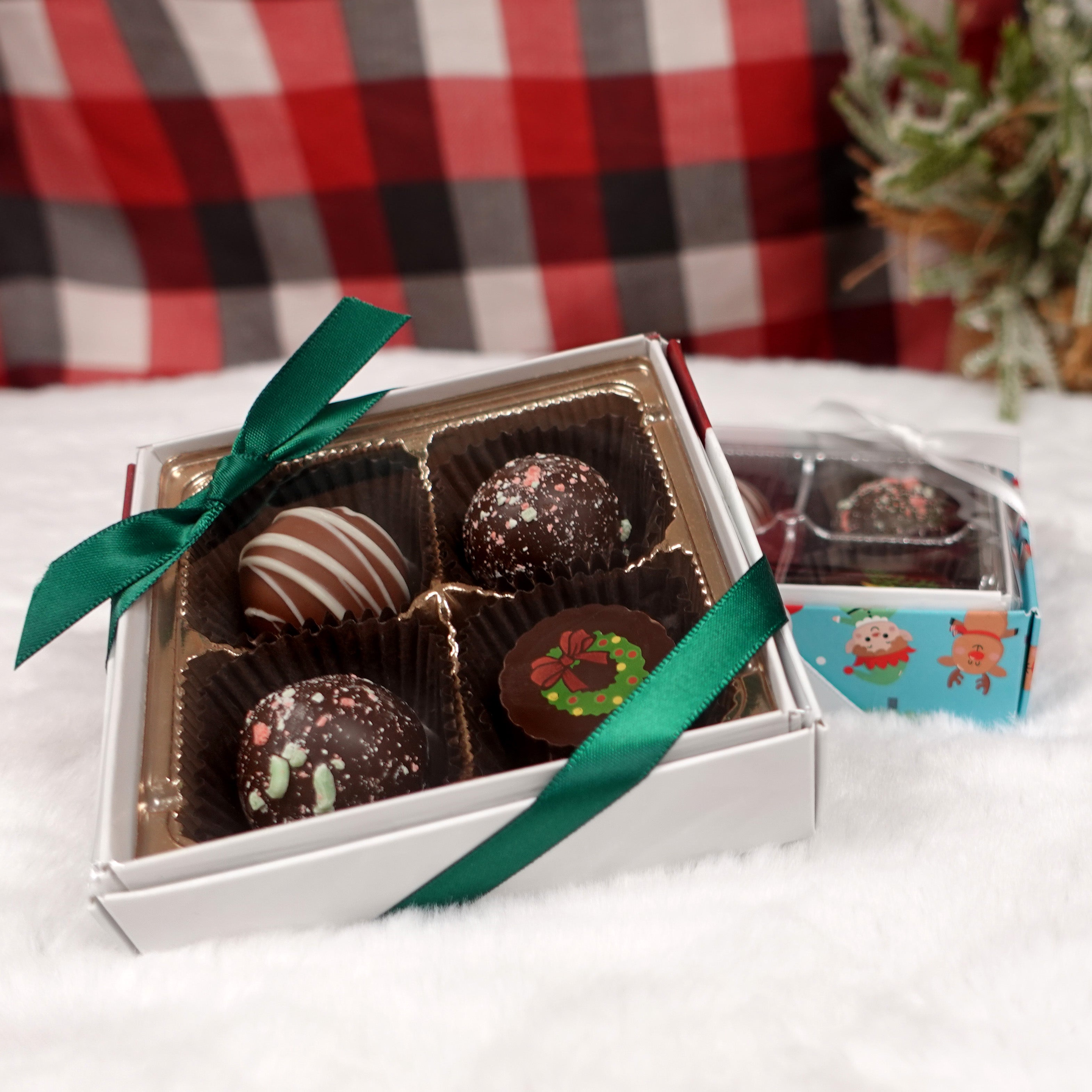 Detail shot of the 4 piece christmas truffle box with egg nog truffles, a chocolate caramel truffle, and a decorated christmas truffle