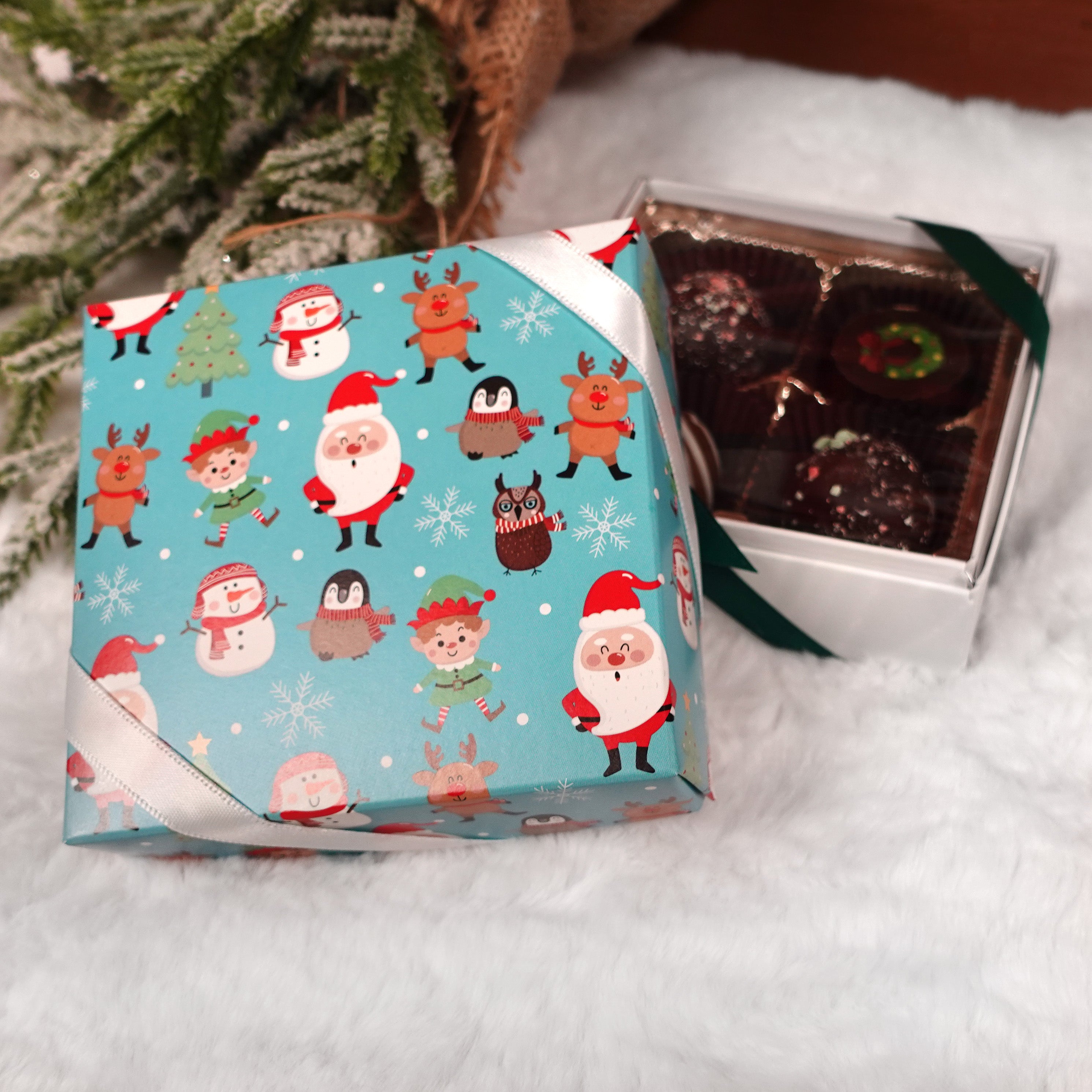 Lore's Chocolates of Philadelphia 4 piece Christmas Icons with chocolate truffles - Santa, Elves, Reindeer, Snowmen, Owls, Snowflakes, and Christmas Tree on a blue background