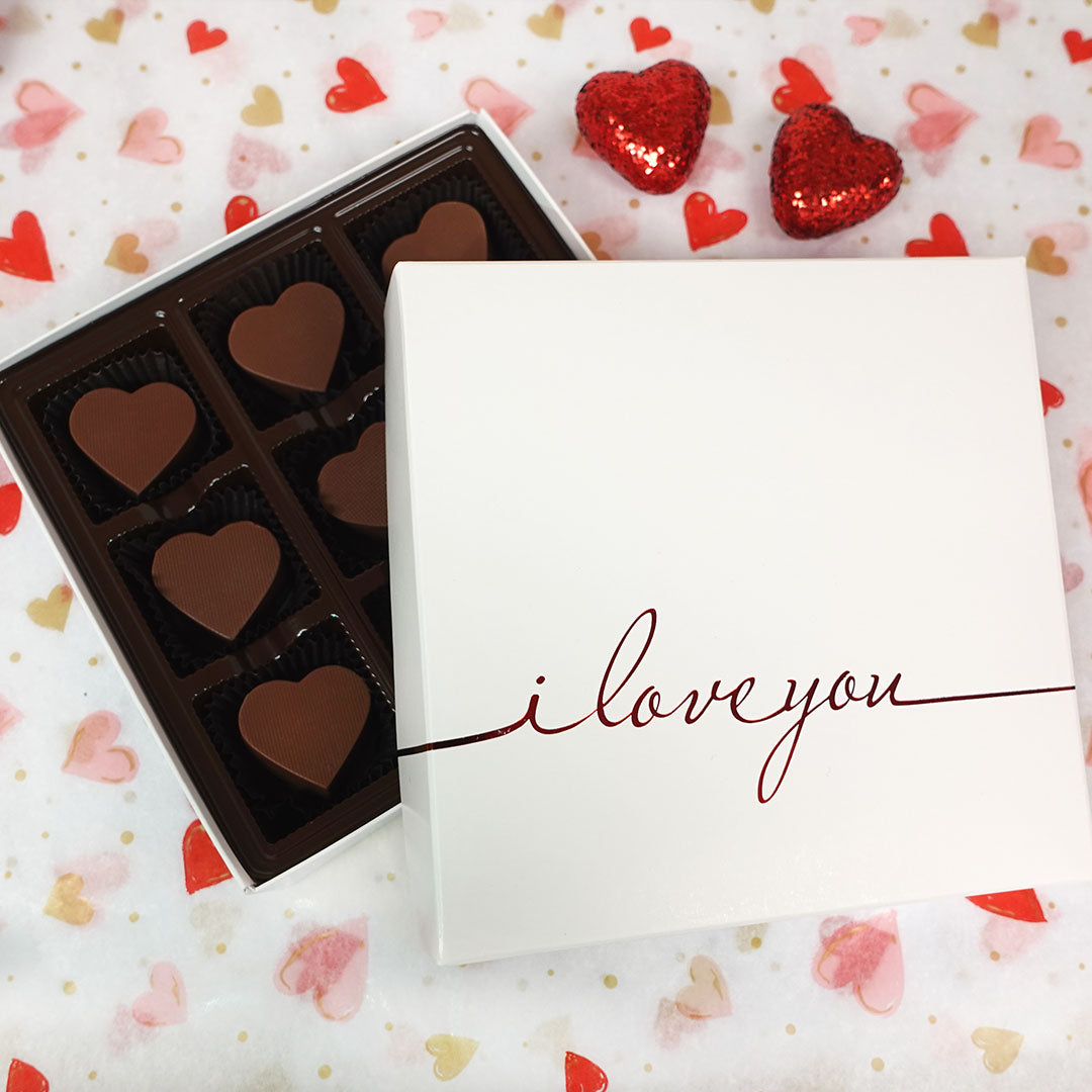 Box of chocolates with 'i love you' on a heart-patterned background