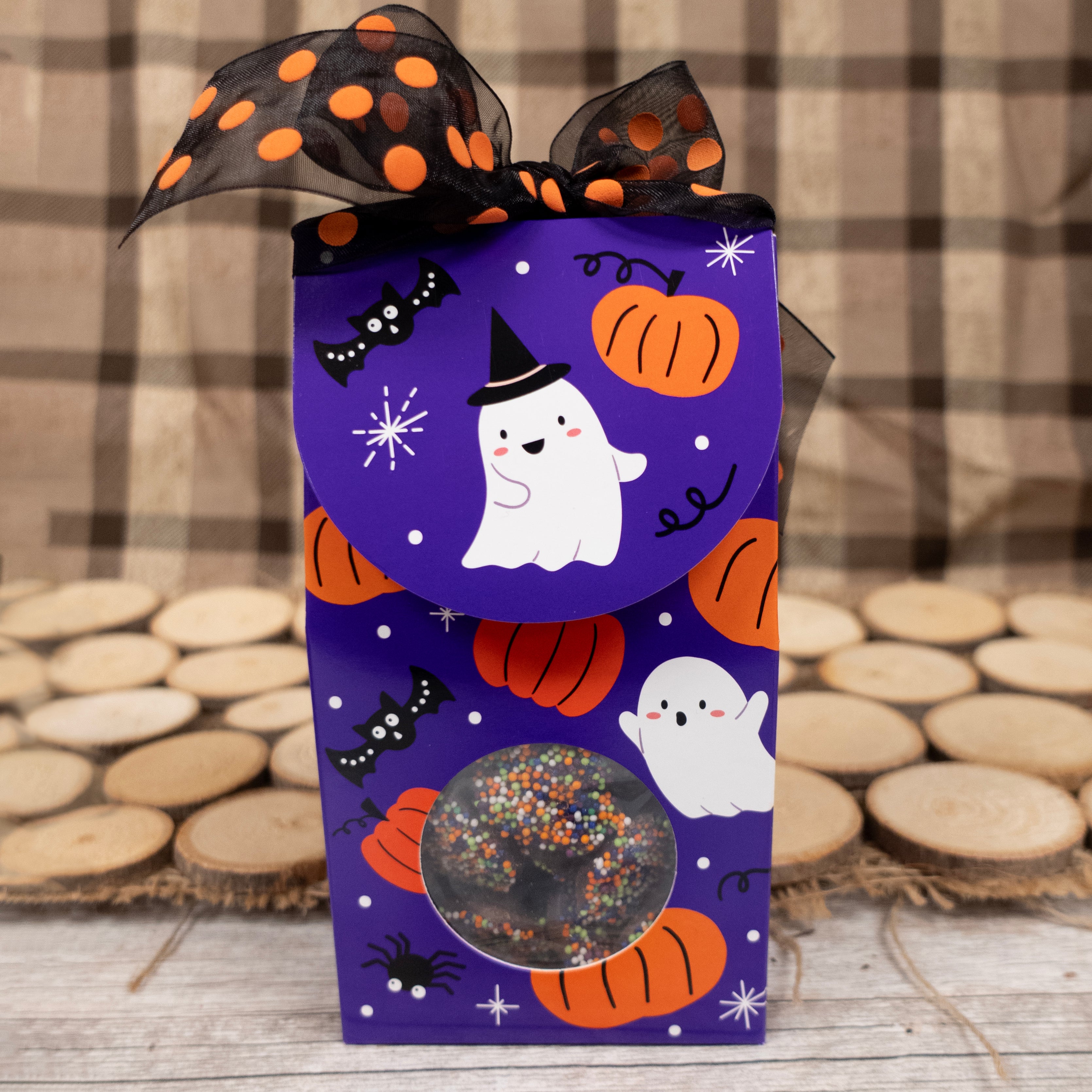 Halloween-themed gift box with purple background, ghosts, pumpkins, and a black bow.