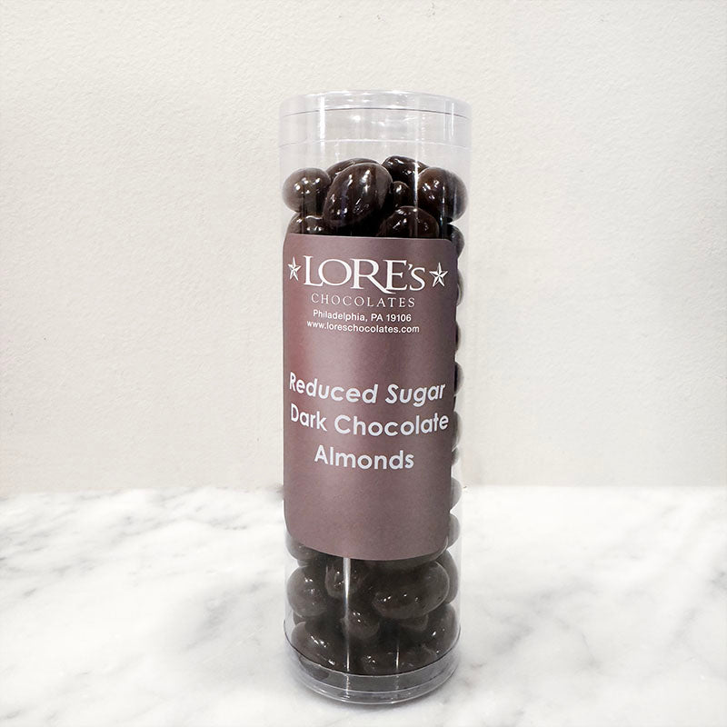Tall cylindrical container of LORE'S CHOCOLATES Reduced Sugar Dark Chocolate Almonds on a white background