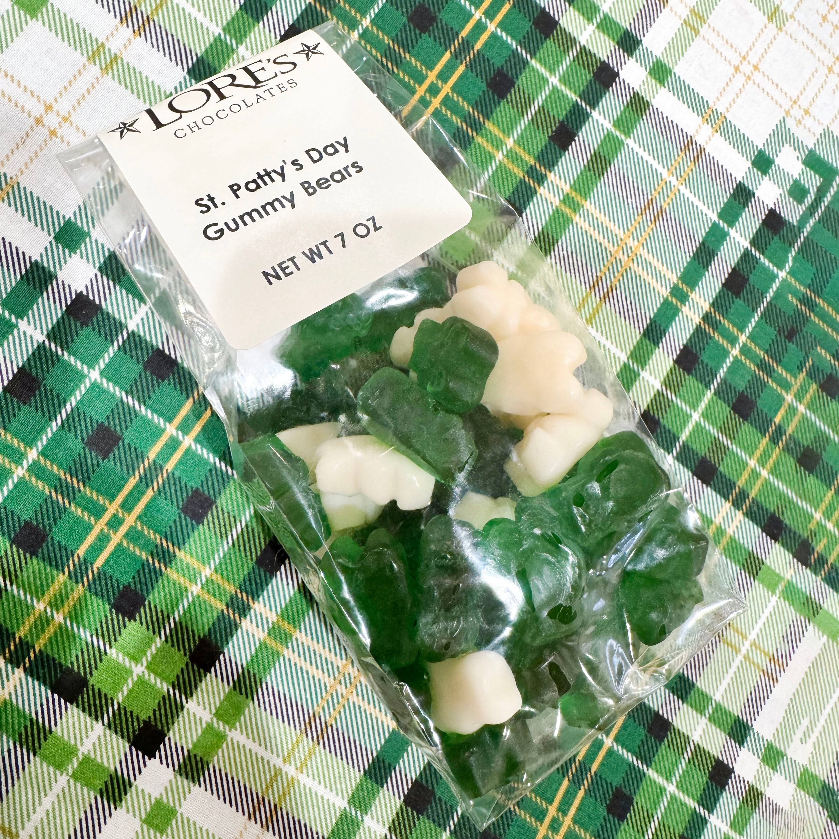 Packaged St. Patrick's Day gummy bears with a Lore's Chocolates label on a green plaid background