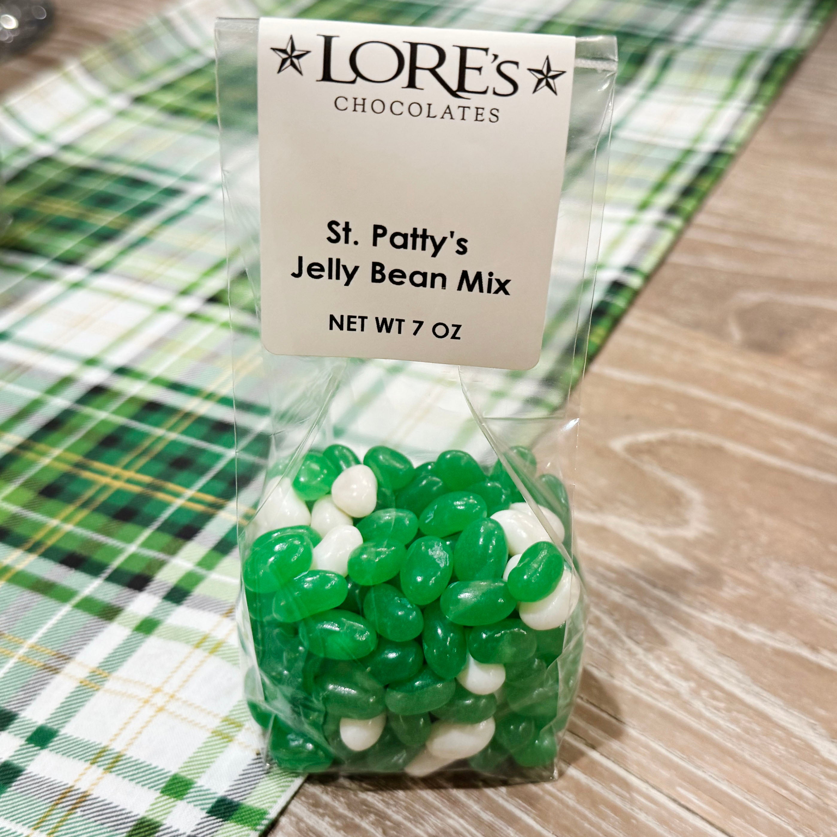 Bag of St. Patrick's Day jelly bean mix from LORE'S CHOCOLATES on a green plaid tablecloth.