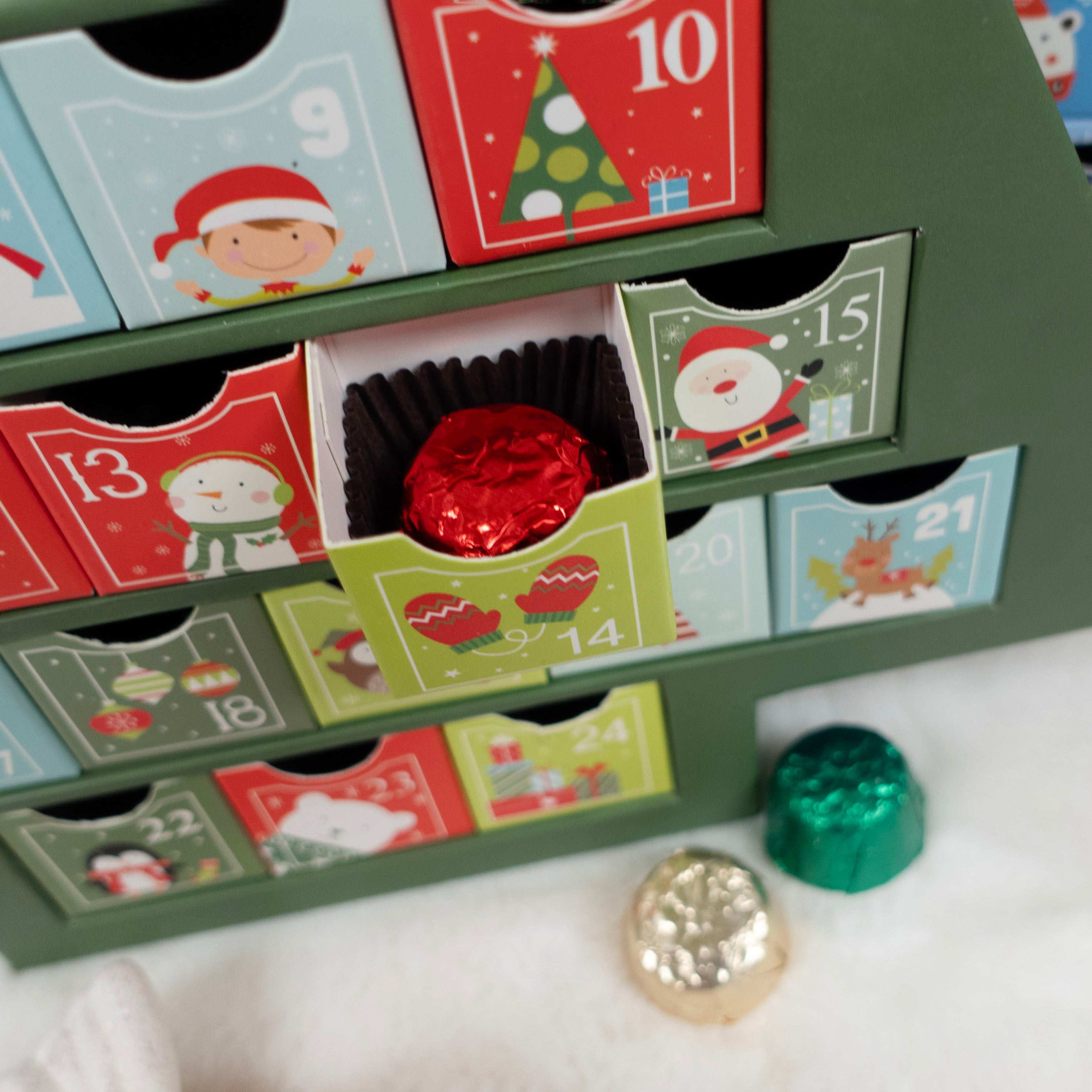 Christmas advent calendar with small doors, some open to reveal wrapped candies.