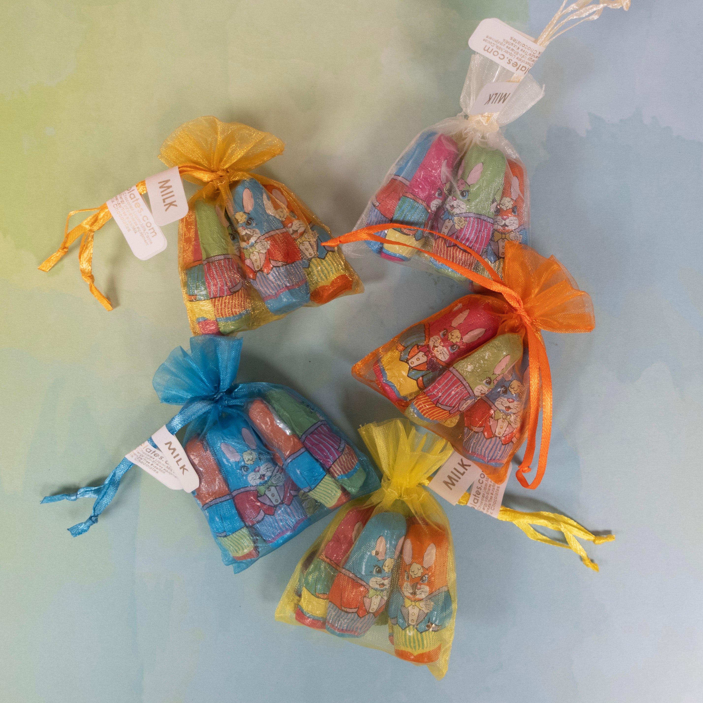 organza bags of various colors with bright standing foiled milk chocolate easter bunnies