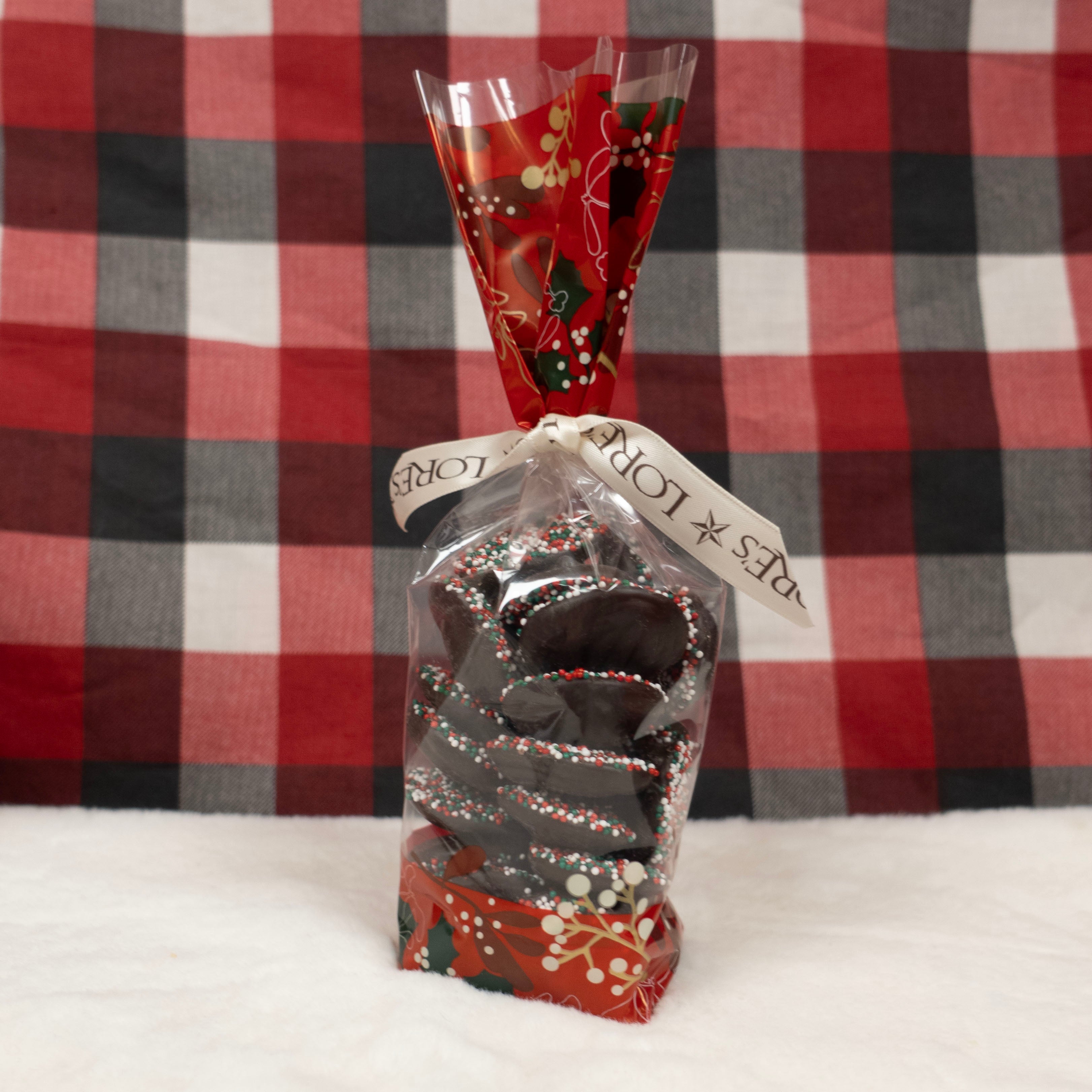 Decorative gift bag of dark chocolate nonpareils with a red and black checkered background