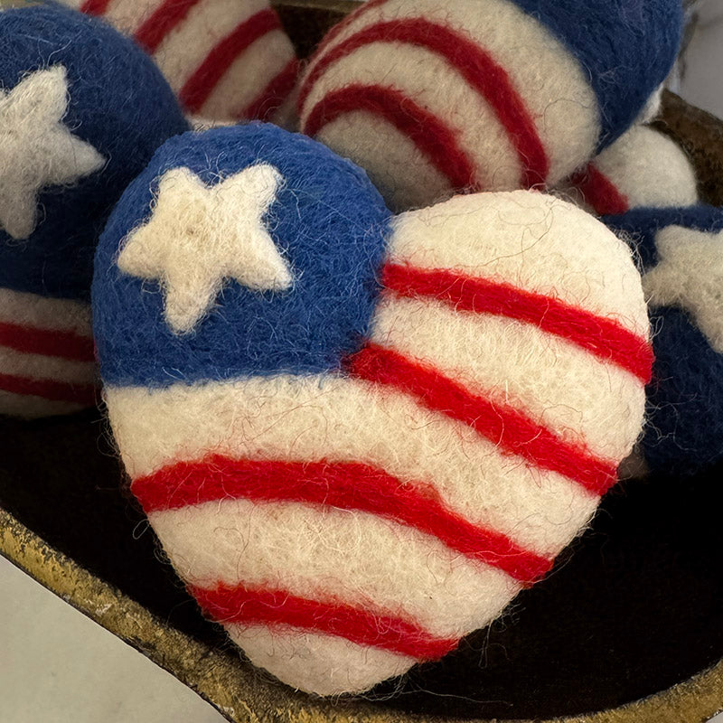 Heart-shaped objects with American flag design on a dark surface
