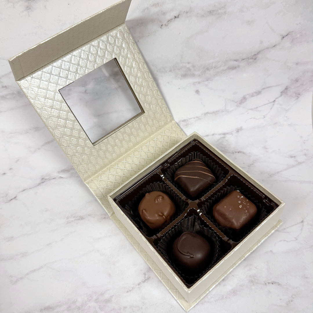 Open box of chocolates on a marble surface