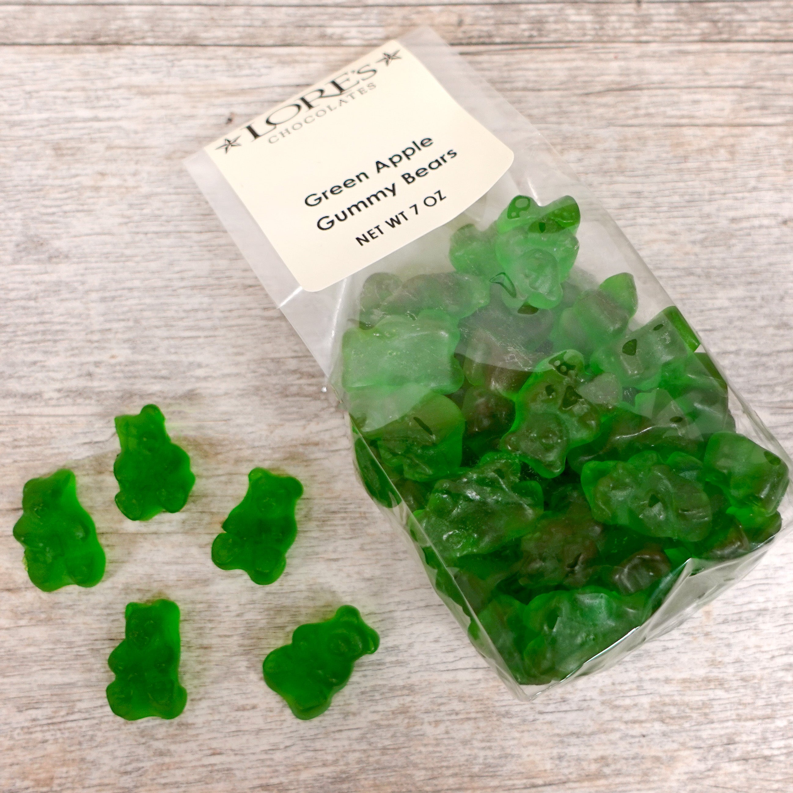 Bright green colors gummy bears with Green Apple Flavor packaged in clear bag - label reads "Lore's Chocolates, Green Apple, Gummy Bears, Net Wt 7 oz" 