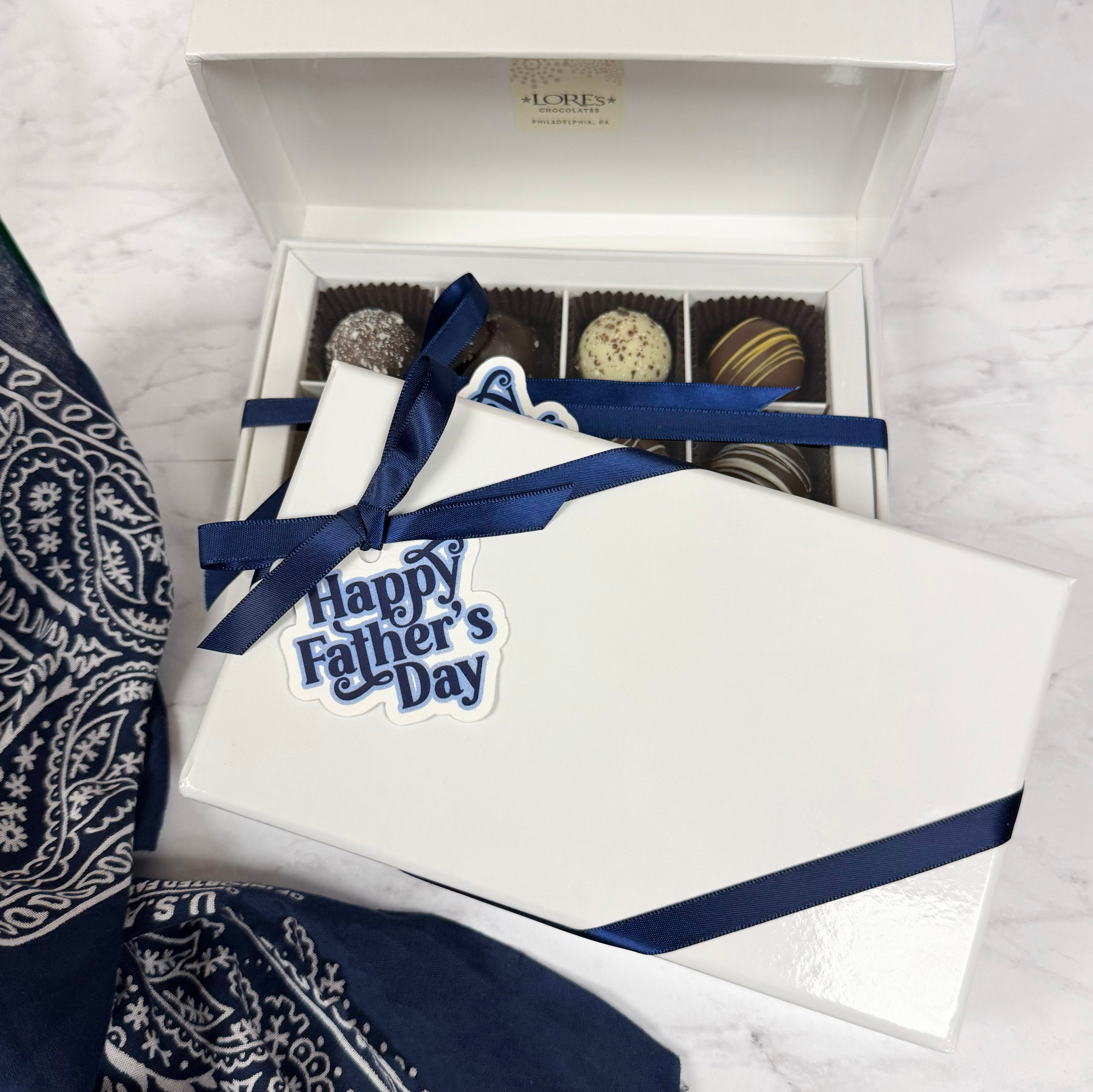 Gift set with 'Happy Father's Day' hang tag, and truffle chocolates on a marble surface