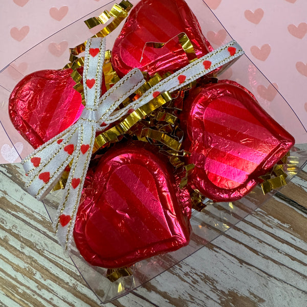 heart shaped milk chocolate covered peanut butter covered in pink foil - clear box with heart ribbon