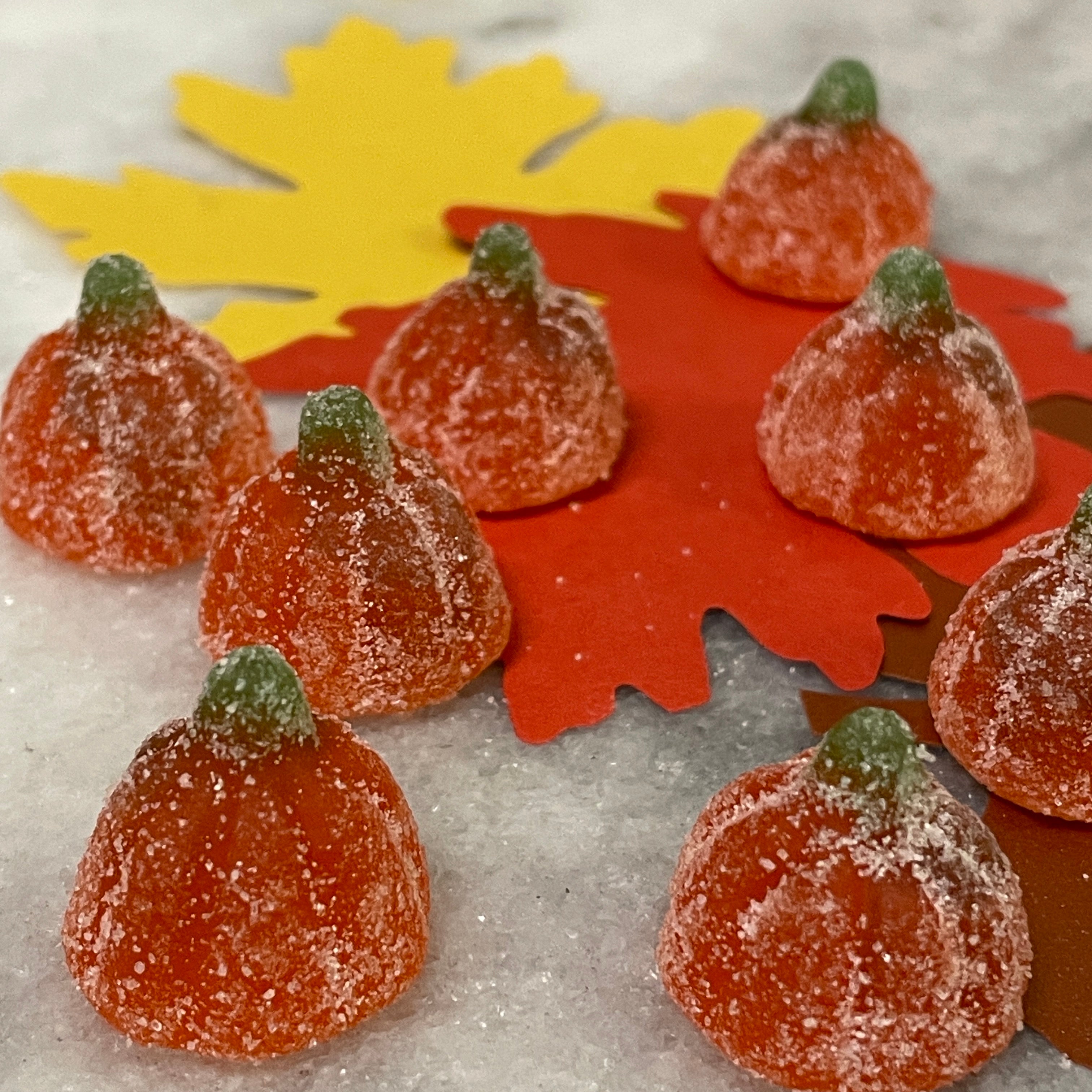 little orange pumpkins with green stems - gummy candies coated in a sour sugar