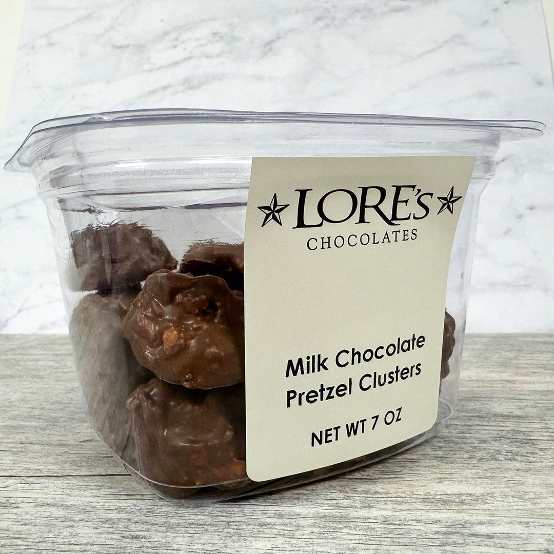 Container of milk chocolate pretzel clusters with a Lore's Chocolates label on a marble background