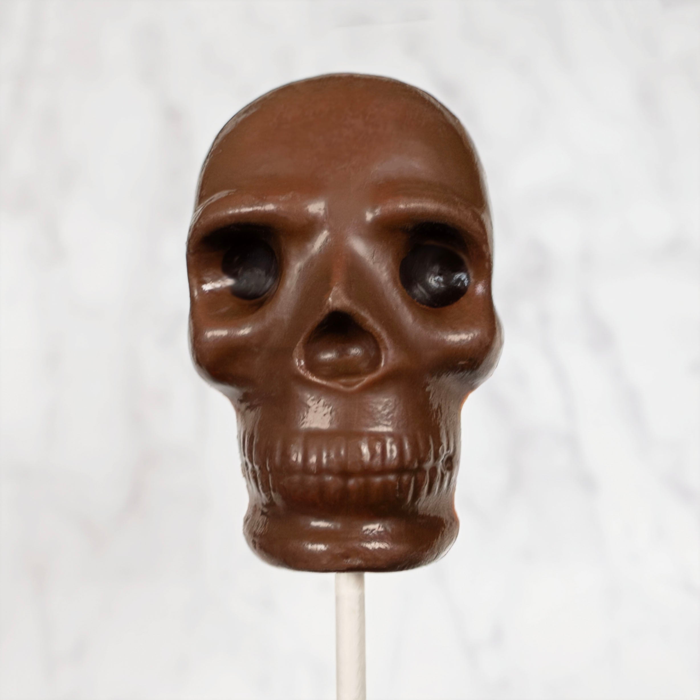 Milk Chocolate skull lollipop on a white background