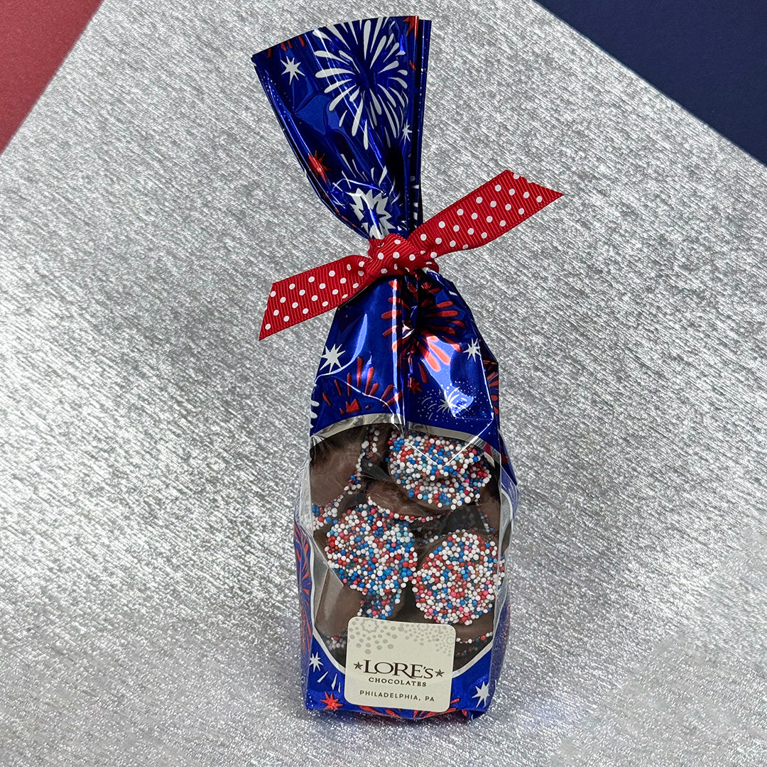 Packaged chocolate nonpareils with a festive design on a textured surface -  Lore's Chocolates in Philadelphia