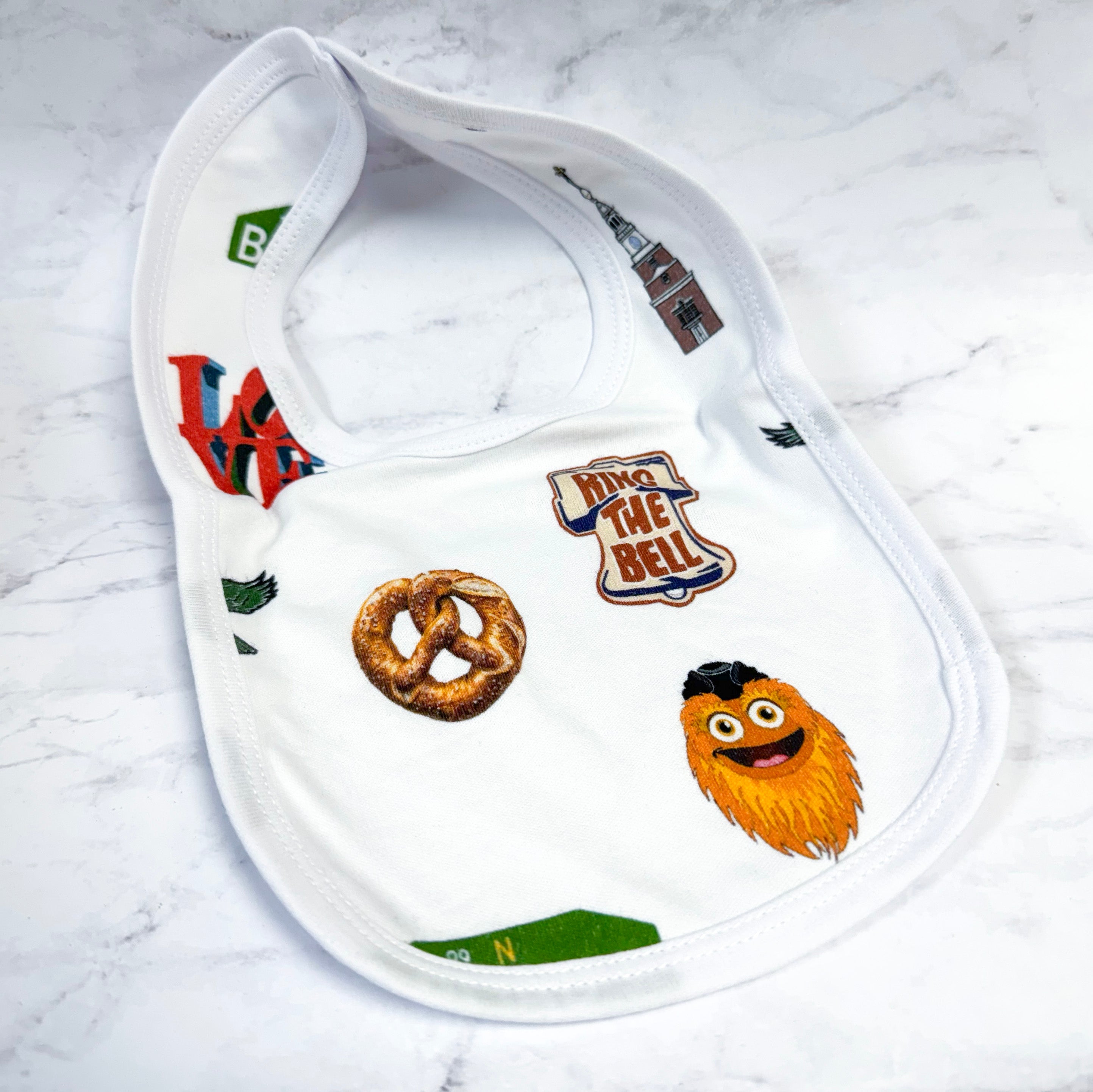 White baby bib with various philadelphia graphics and text on a white background