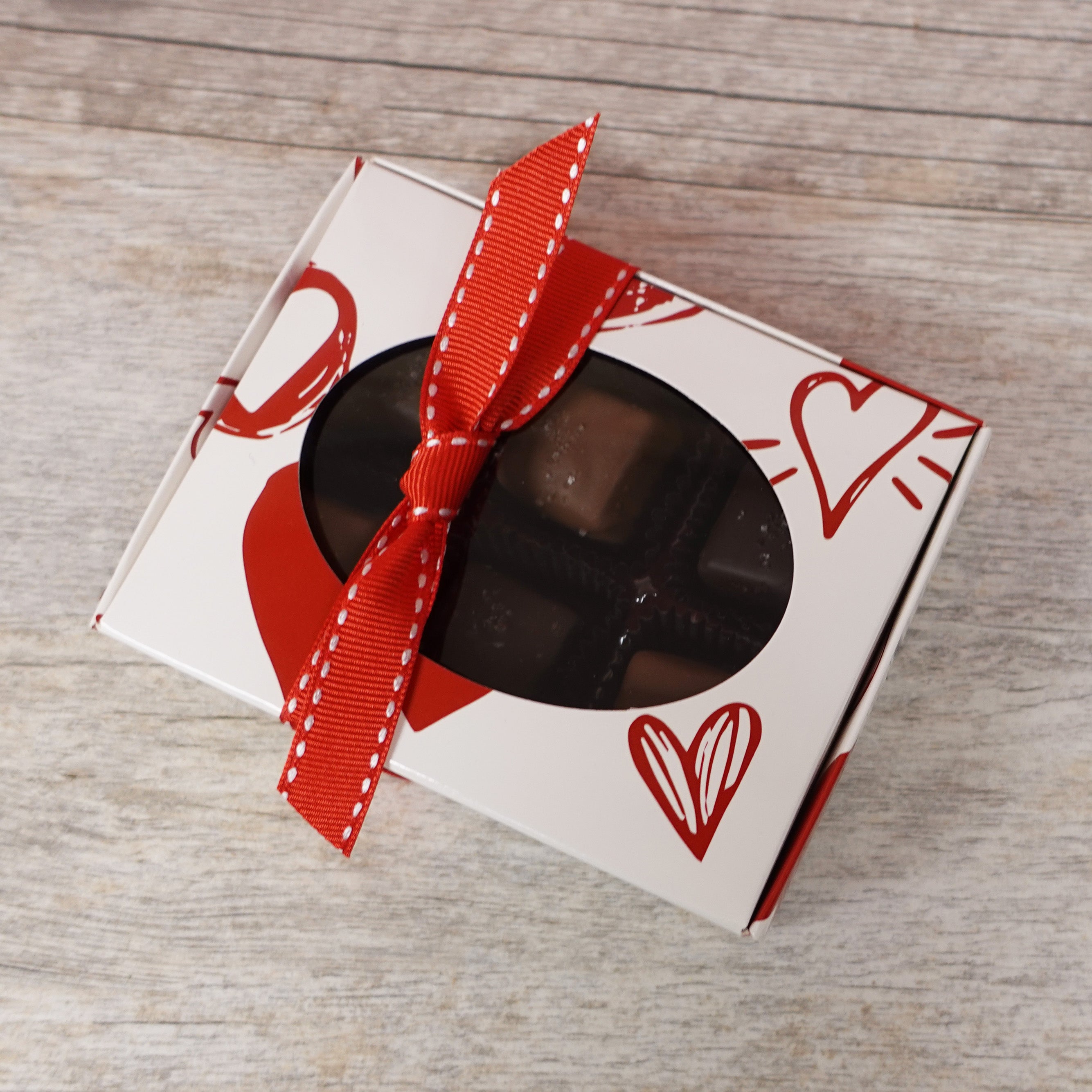 Lore's Chocolates Milk and Dark Sea Salt Caramels in 6 pack white gift box with red doodle hearts and a red ribbon