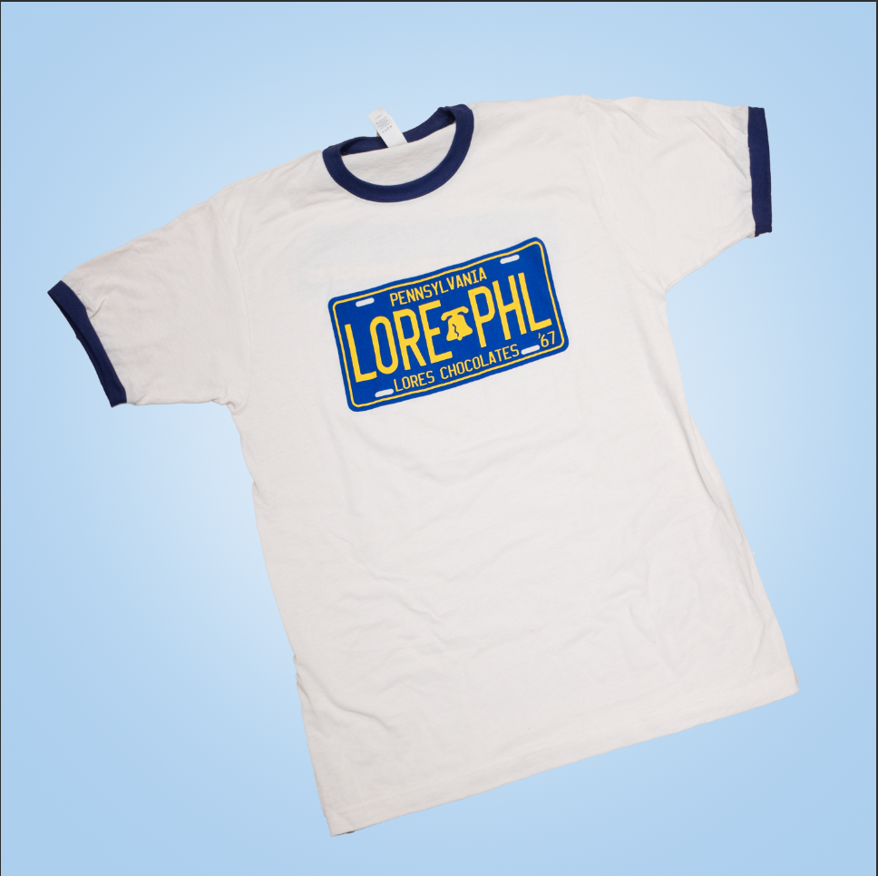 lore's chocolates vintage white t-shirt with dark blue ringer sleeves and neck. front of the shirt - PA Bicentennial License plate design "Pennsylvania, LORE (liberty bell) PHL, Lore's Chocolates, '67" 