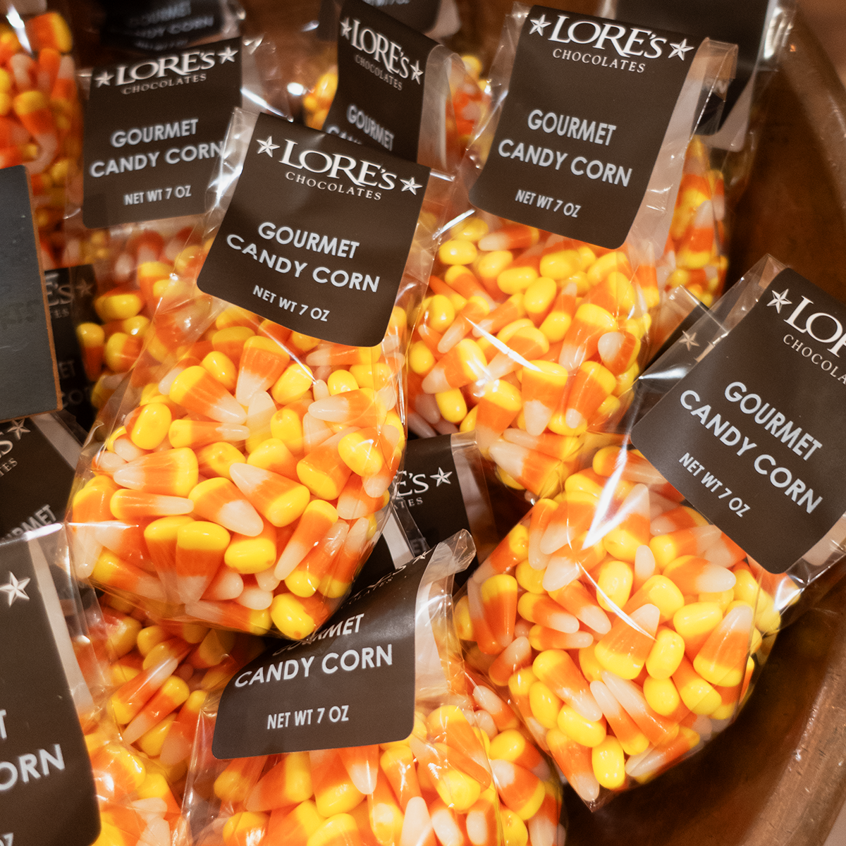 A copper bowl of bagged gourmet candy corn