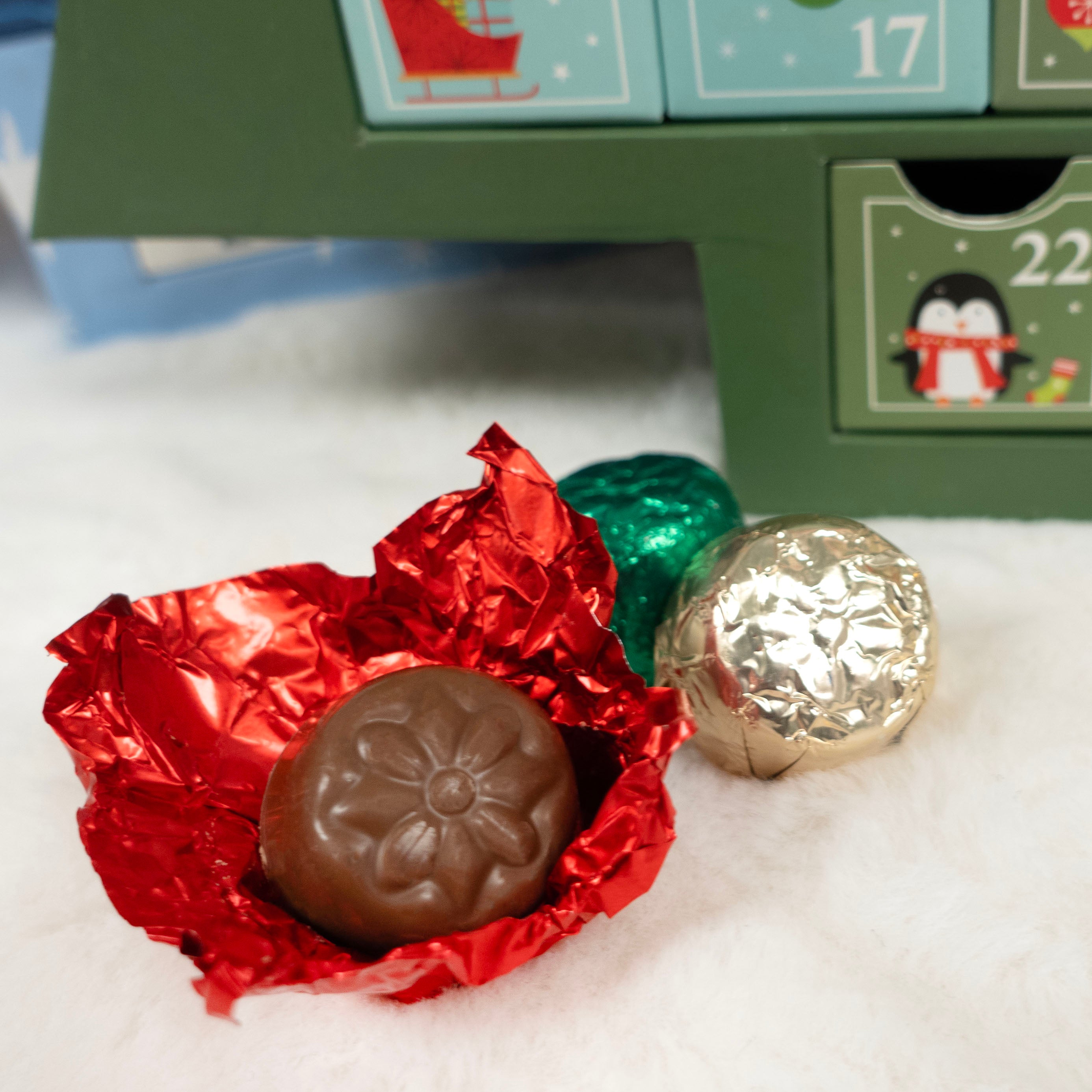 Milk Chocolate candy in red foil with a advent calendar in the background