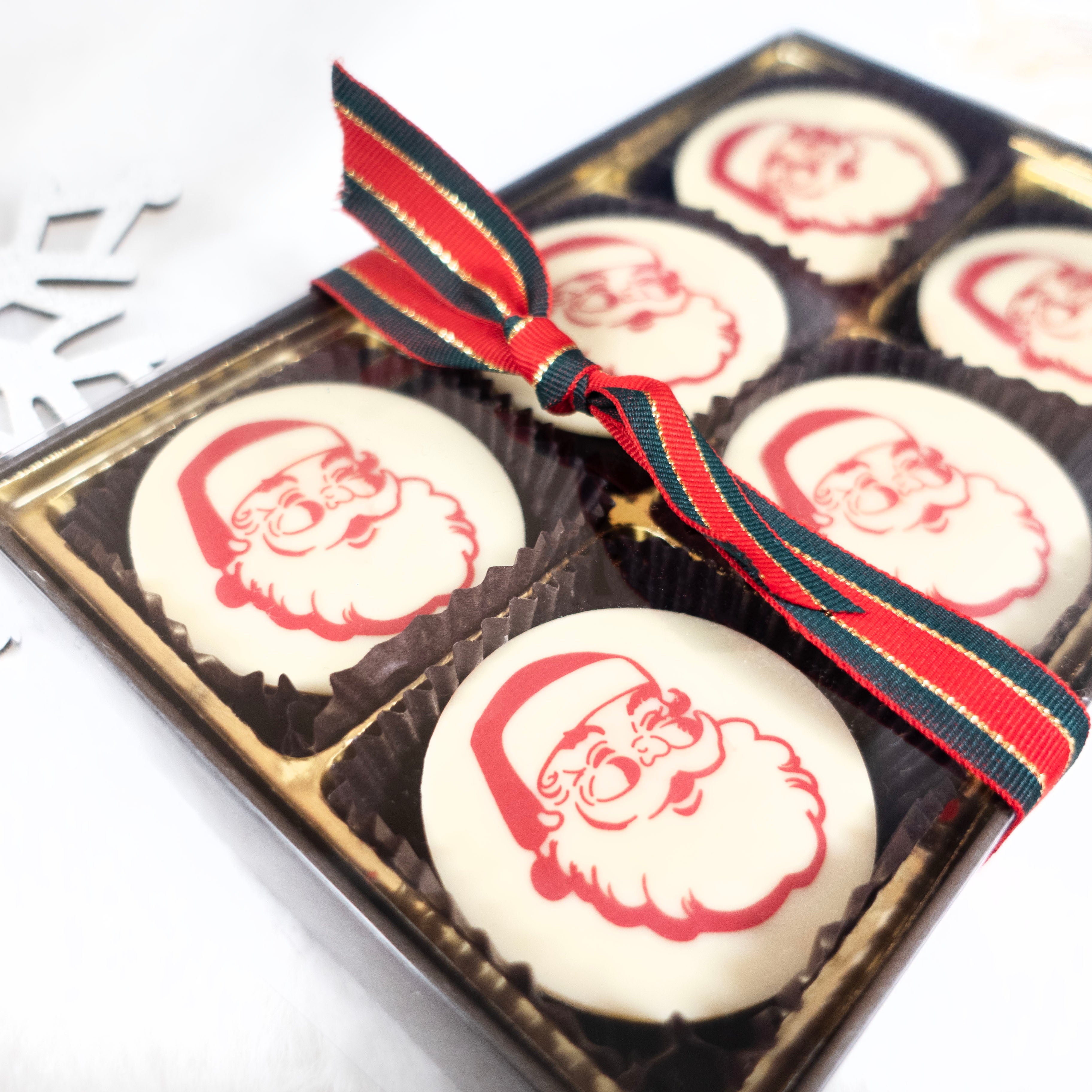 Box of chocolate oreos with Santa Claus design on a white background