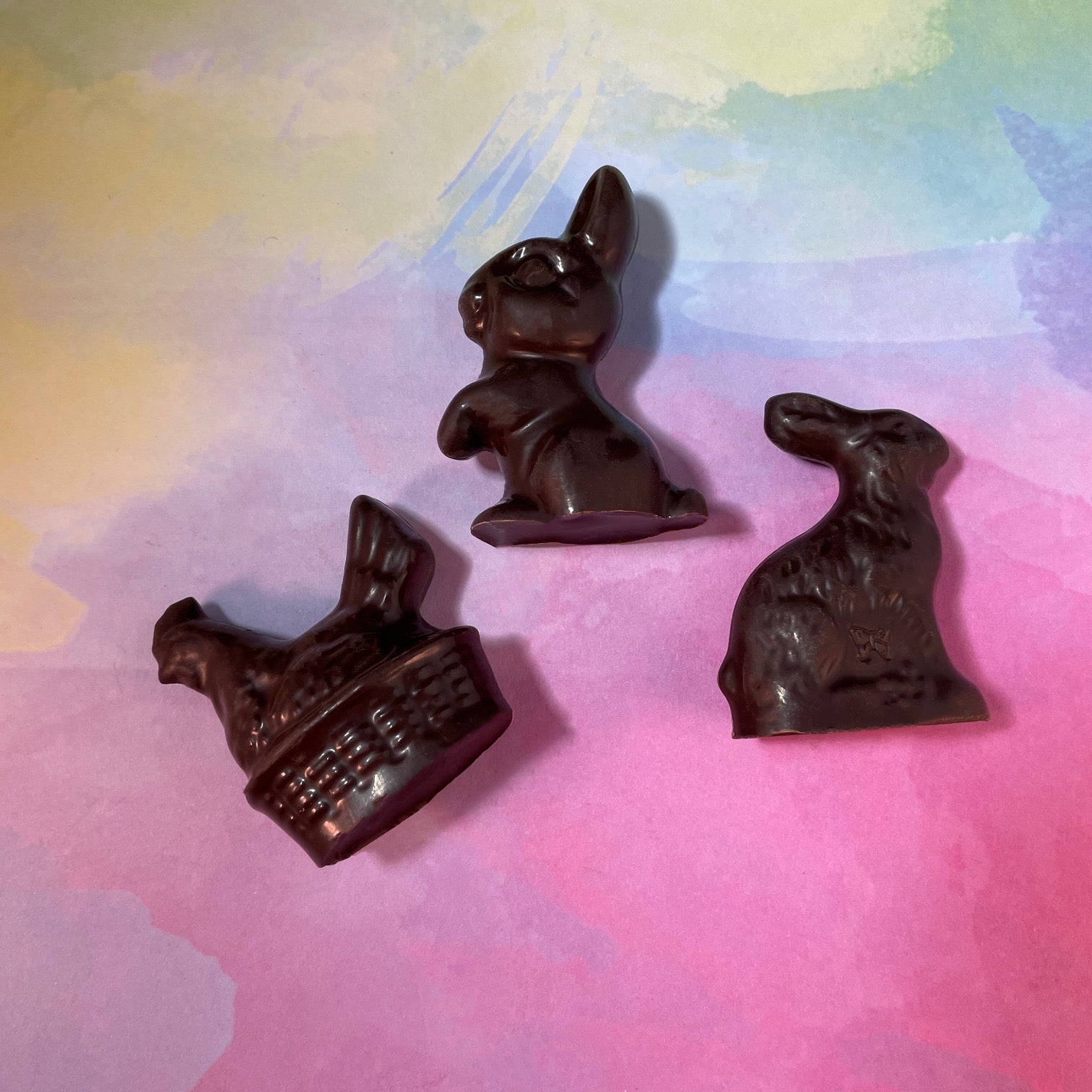 three small solid dark chocolate Easter molds - chicken in basket, hopping bunny, and sitting rabbit