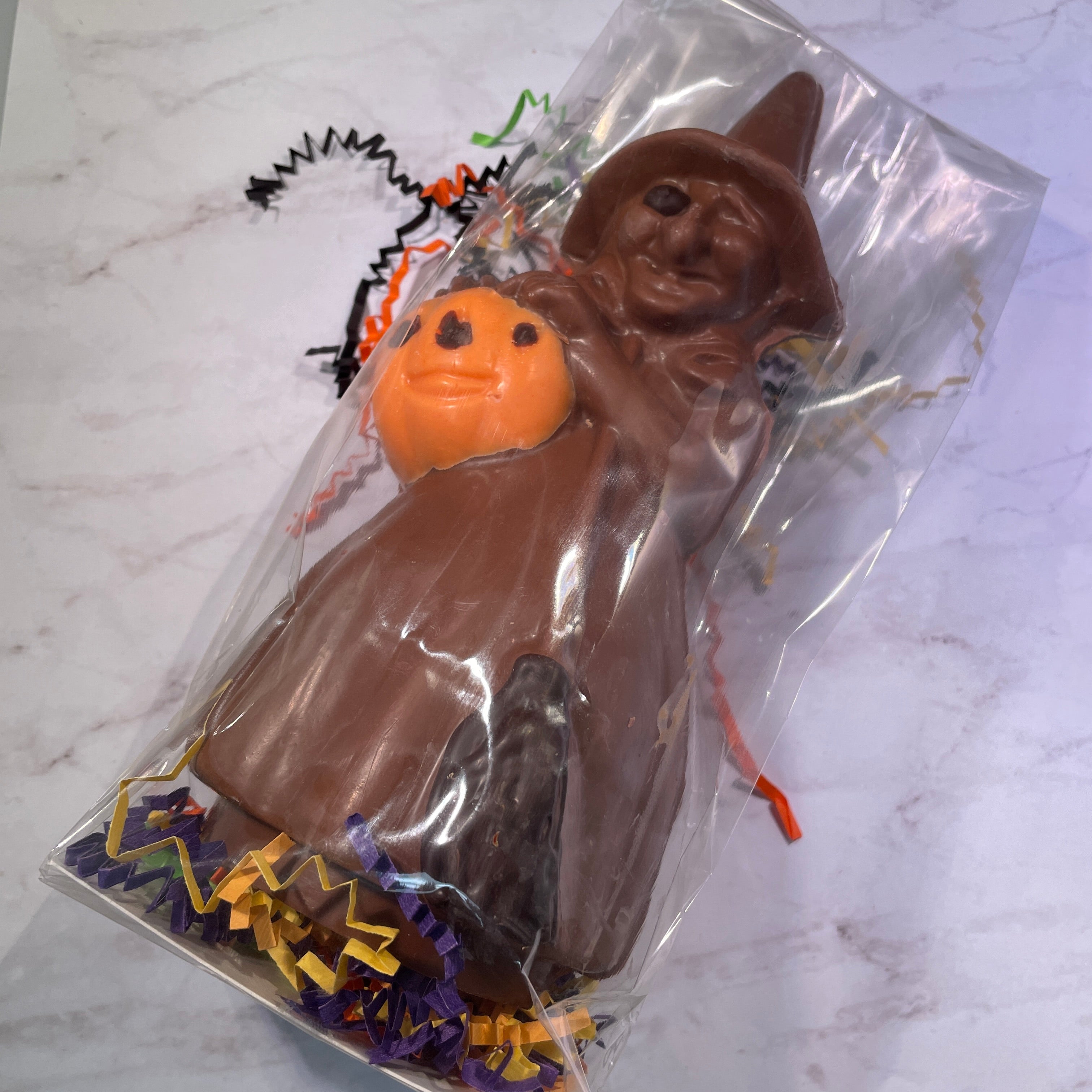 Large witch milk chocolate mold holding a white chocolate orange pumpkin with dark chocolate accents