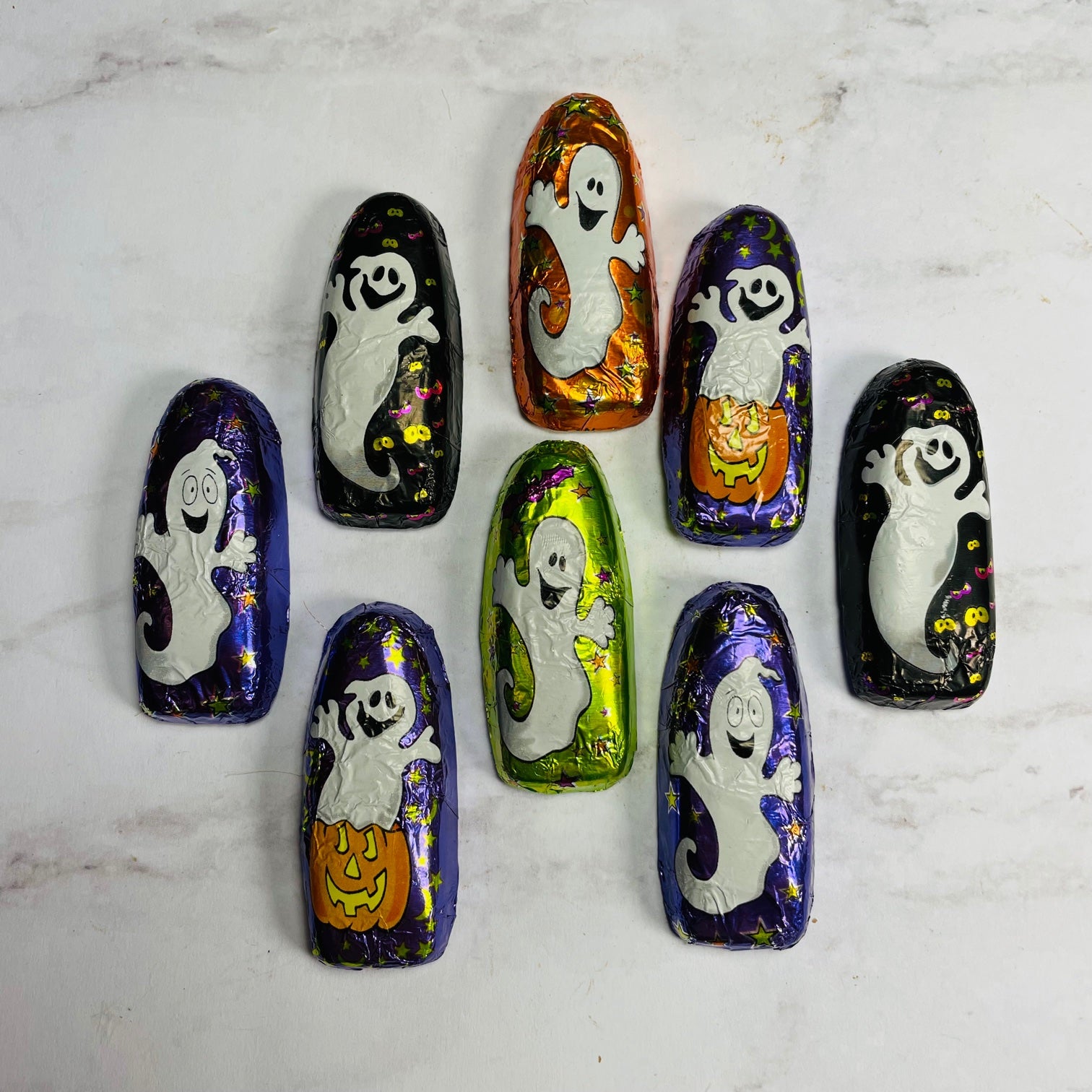 Milk chocolate foiled in cute Halloween ghost designs coming in purple, black, orange, and green