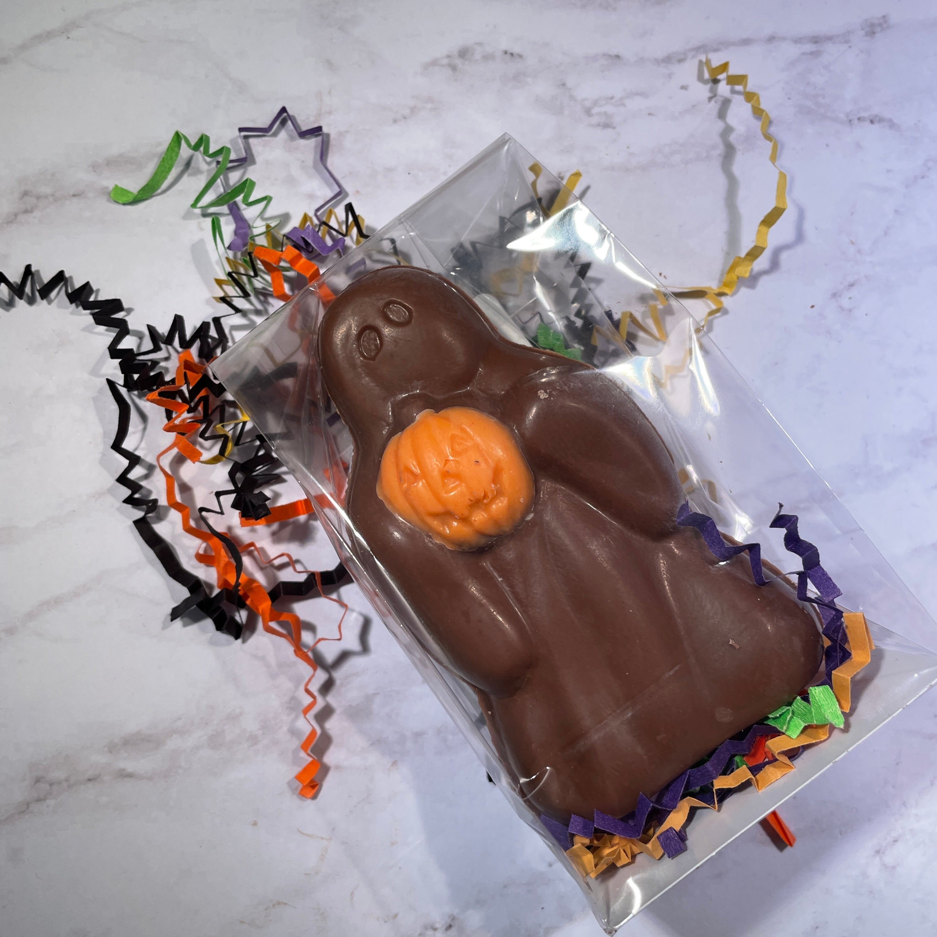 Milk chocolate Ghost holding an orange pumpkin.